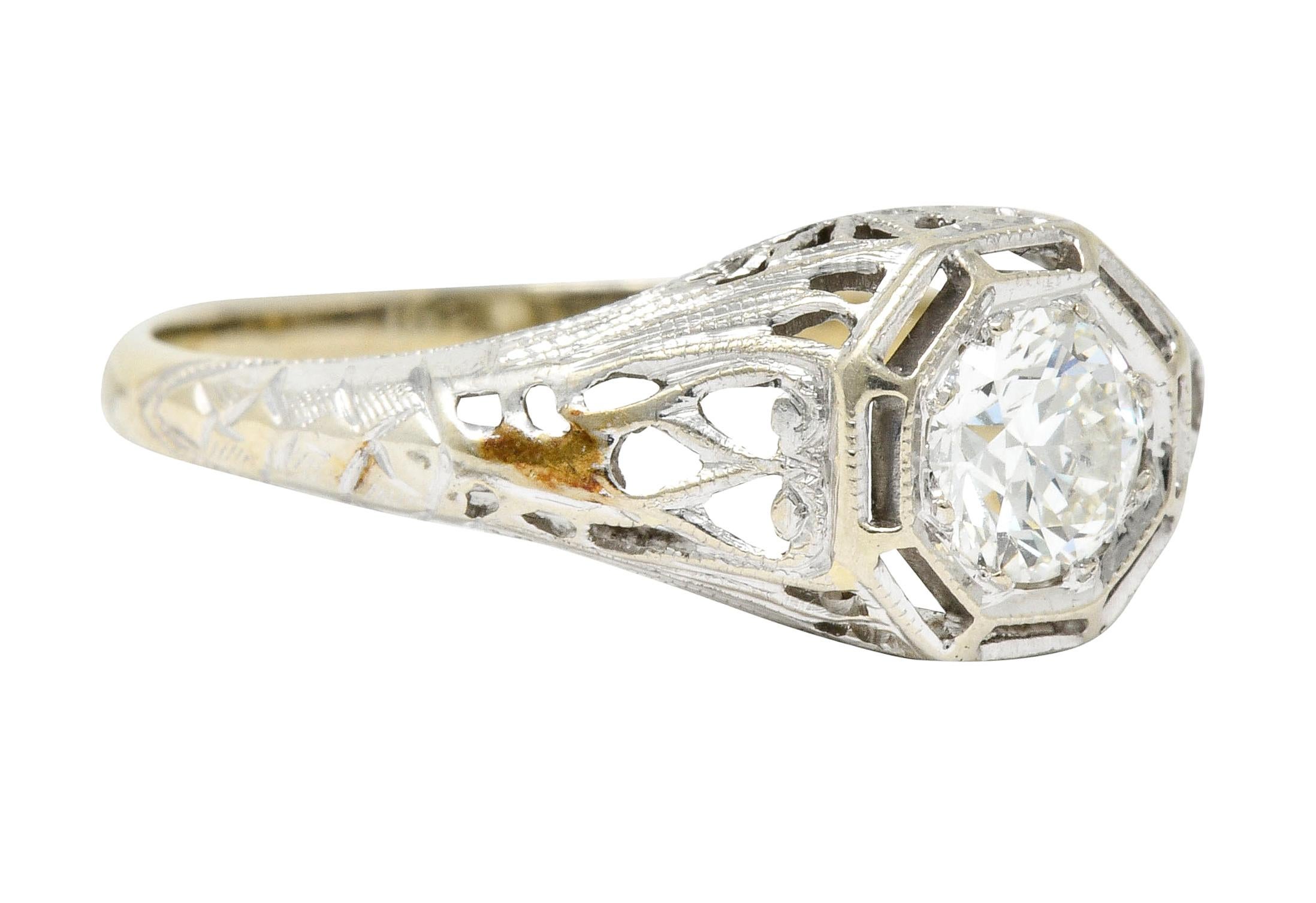 Centering an old European cut diamond weighing approximately 0.61 carat, H color with  VS1 clarity

Set low in a hexagonal head of an intricately pierced mounting with engraved details

Tested as 18 karat gold

Circa: 1930s

Ring Size: 9 &