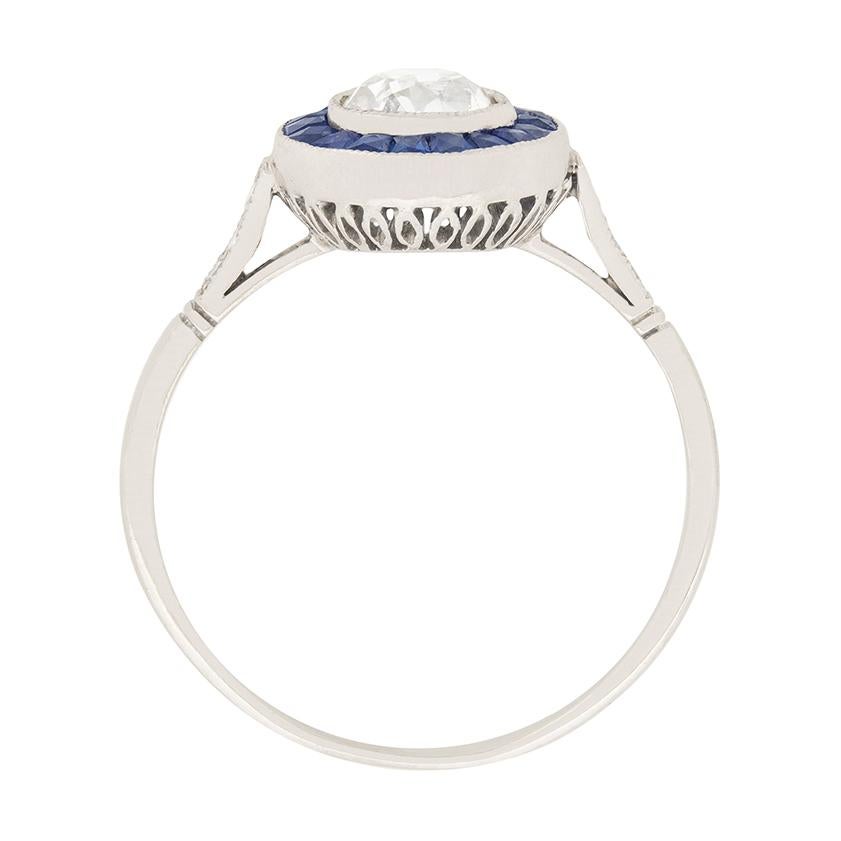 This beautiful art deco target ring features a 0.62 carat old cut diamond surrounded by a halo of french cut sapphires. The diamond is an I colour and VS1 clarity. The sapphires total to 0.40 carat, and are cut to fit perfectly in the halo. There