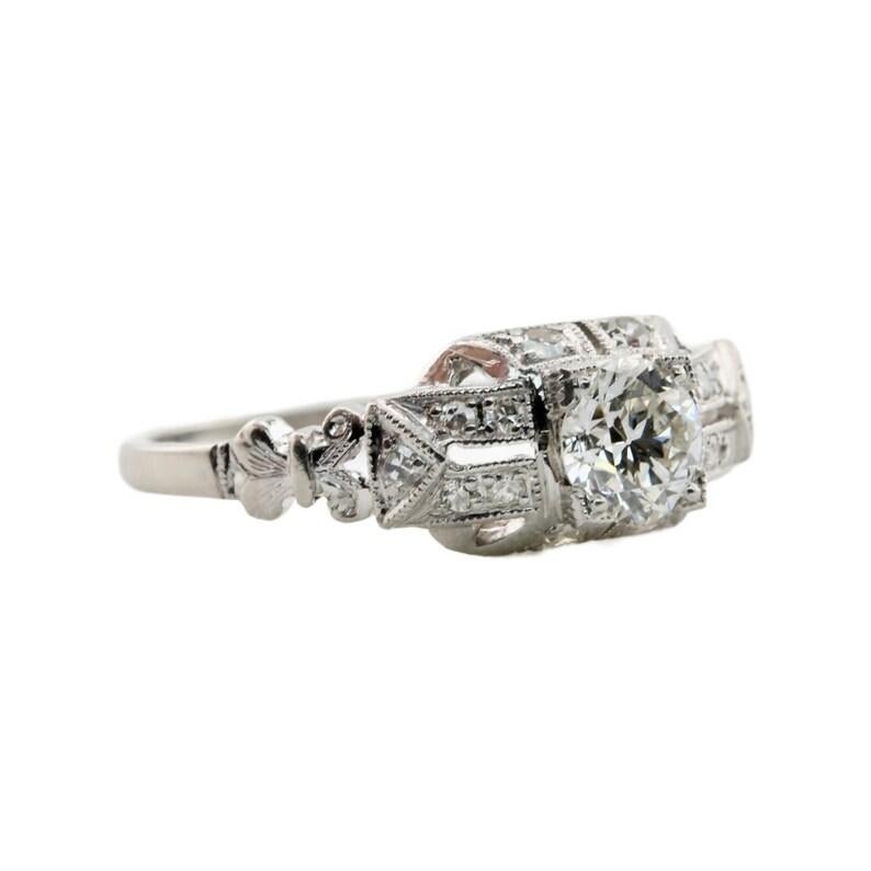 Aston Estate Jewelry Presents:

An original Art Deco diamond engagement ring in platinum. Centered by a 0.50 carat old European cut diamond of G color and VS1 clarity. Accented by 0.14 carats of pave set diamonds throughout. Completed by beautiful