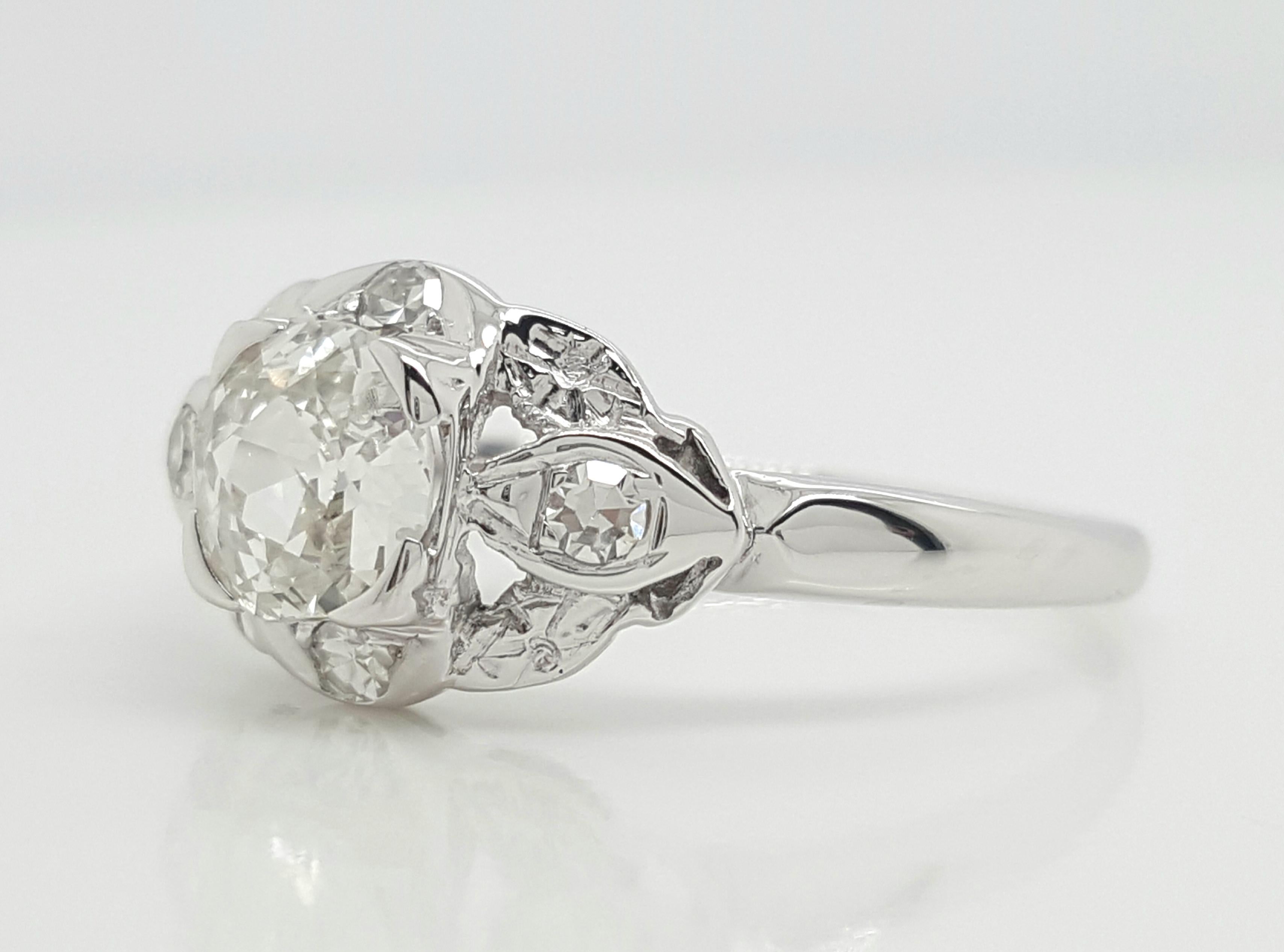 Dieser klassische Diamant-Verlobungsring besteht aus einem lebendigen, europäisch geschliffenen Diamanten von 0,65 Karat, der von 4 kleineren, einzeln geschliffenen Diamanten akzentuiert wird, die das Zentrum flankieren und von Schulter zu Schulter