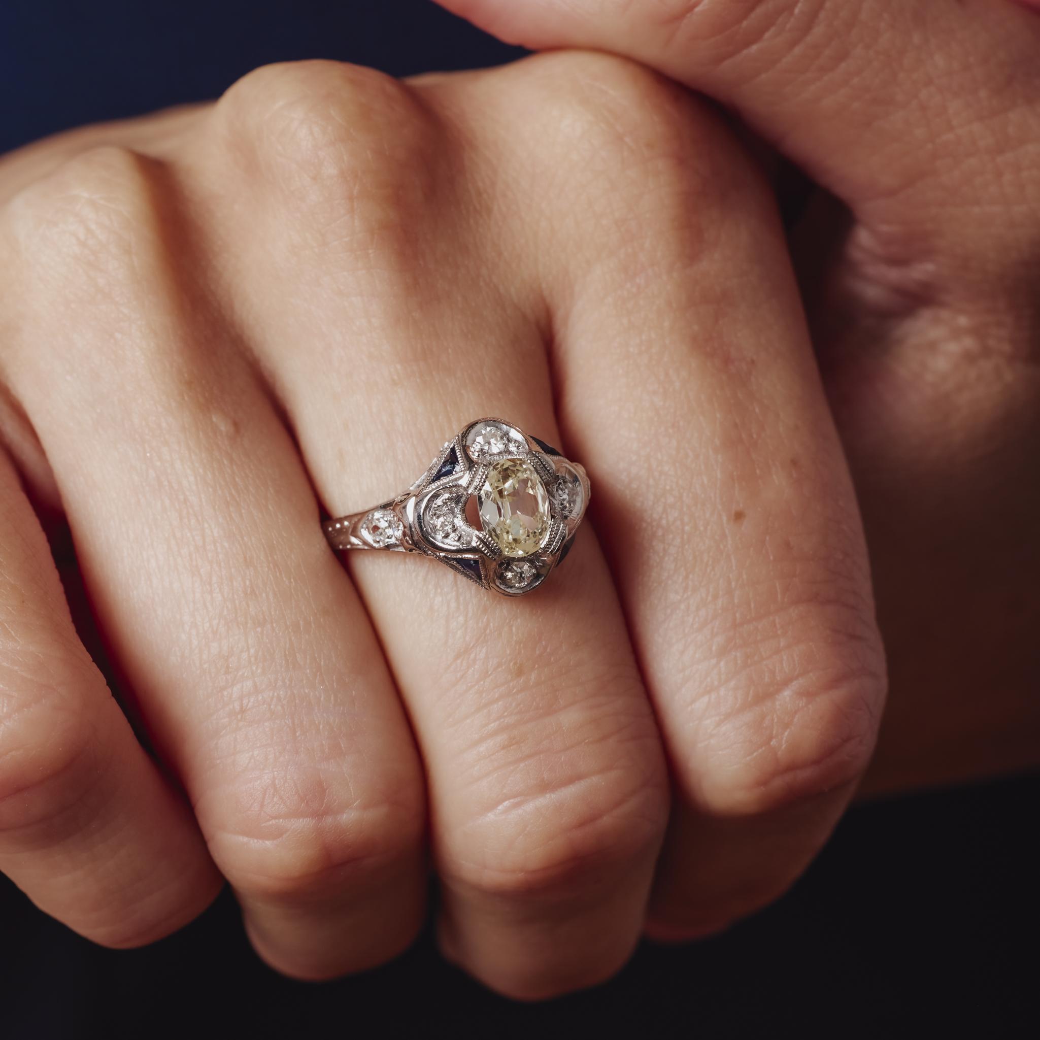 Questo elegante anello in platino Art Déco mette in mostra un diamante taglio old mine da 0,70 carati incorniciato da scintillanti diamanti taglio singolo e da vivaci zaffiri blu in un raffinato design geometrico.