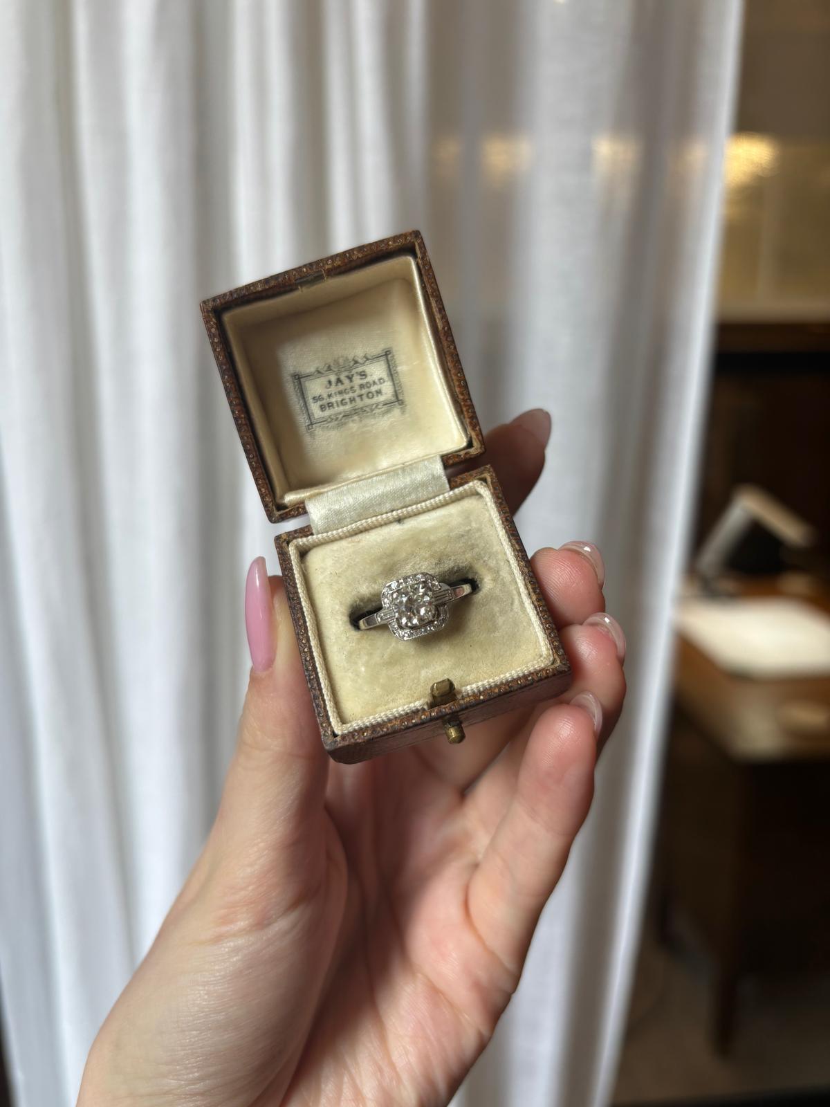 A beautiful Art Deco old mine cut diamond ring set in platinum. 

The ring is centrally set with a beautiful 0.70 carat old mine cut diamond. The diamond is securely four claw set in an open work squared setting. The diamond is sided by two baguette