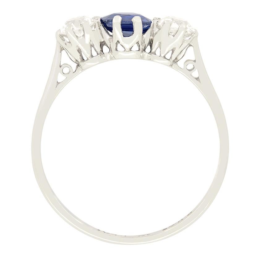 A vibrant blue sapphire is flanked by two old cut diamonds in this 1920s trilogy ring. The central sapphire is a 0.70 carat oval cut stone, claw set into platinum. The diamond pair are both old cut stones, weighing 0.40 carat a piece provide