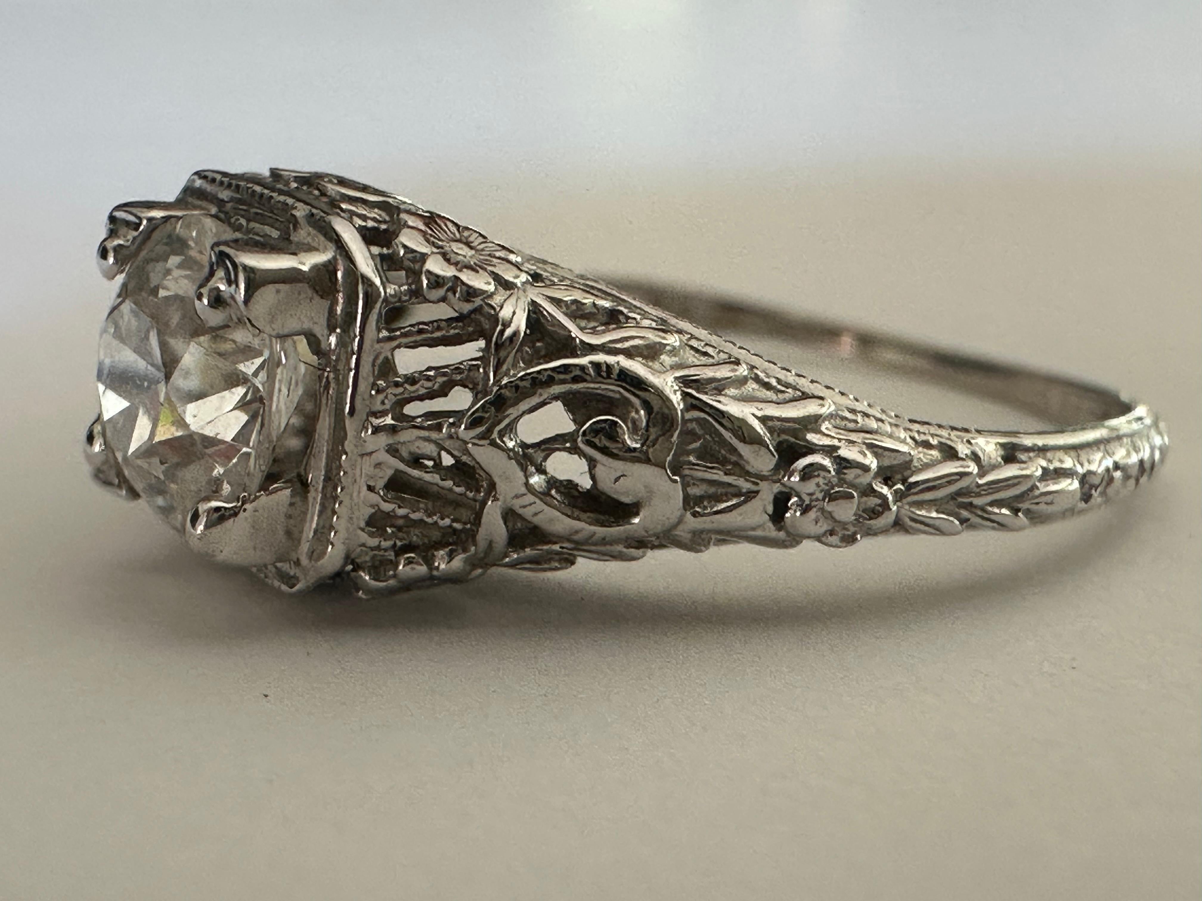 Ein Diamant im Old-European-Schliff mit einem Gewicht von ca. 0,72 Karat, Farbe F-G, Reinheit SI1, glänzt in diesem Solitärring im Art-Déco-Stil auf einer fantasievollen, filigranen Fassung. Fassung aus 18 Karat Weißgold. Der Diamant misst 5,72 x