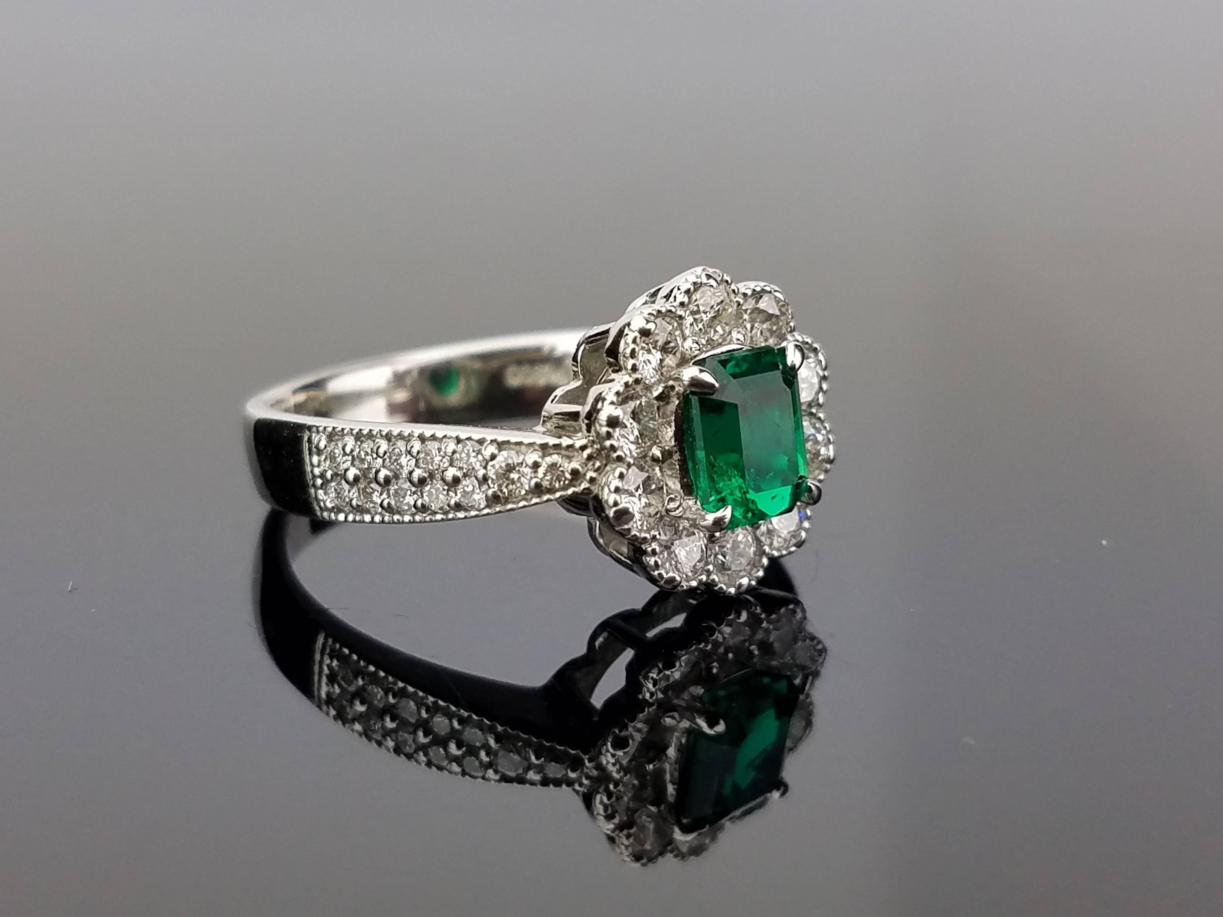 An elegant art deco with a stunning, lustrous Emerald centre stone surrounded with white Diamond, all set in platinum. 

Stone Details: 
Stone: Emerald
Carat Weight: 0.72 Carats

Diamond Details: 
Total Carat Weight: 0.67 carat
Quality: VS/SI ,