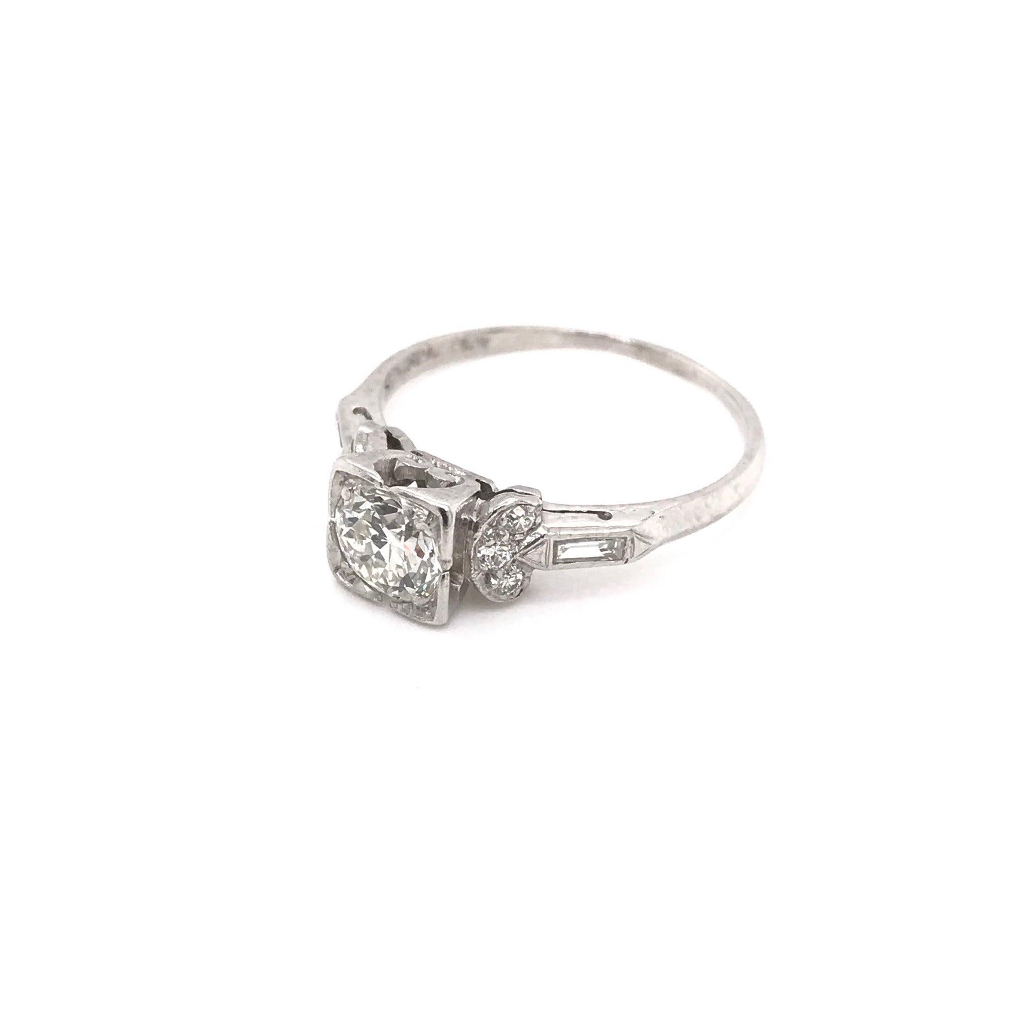 This ring was handcrafted sometime during the Art Deco design period ( 1920-1940 ). The setting is platinum and features a center diamond measuring approximately 0.75 carats. The center diamond grades approximately J in color, VS2 in clarity. The