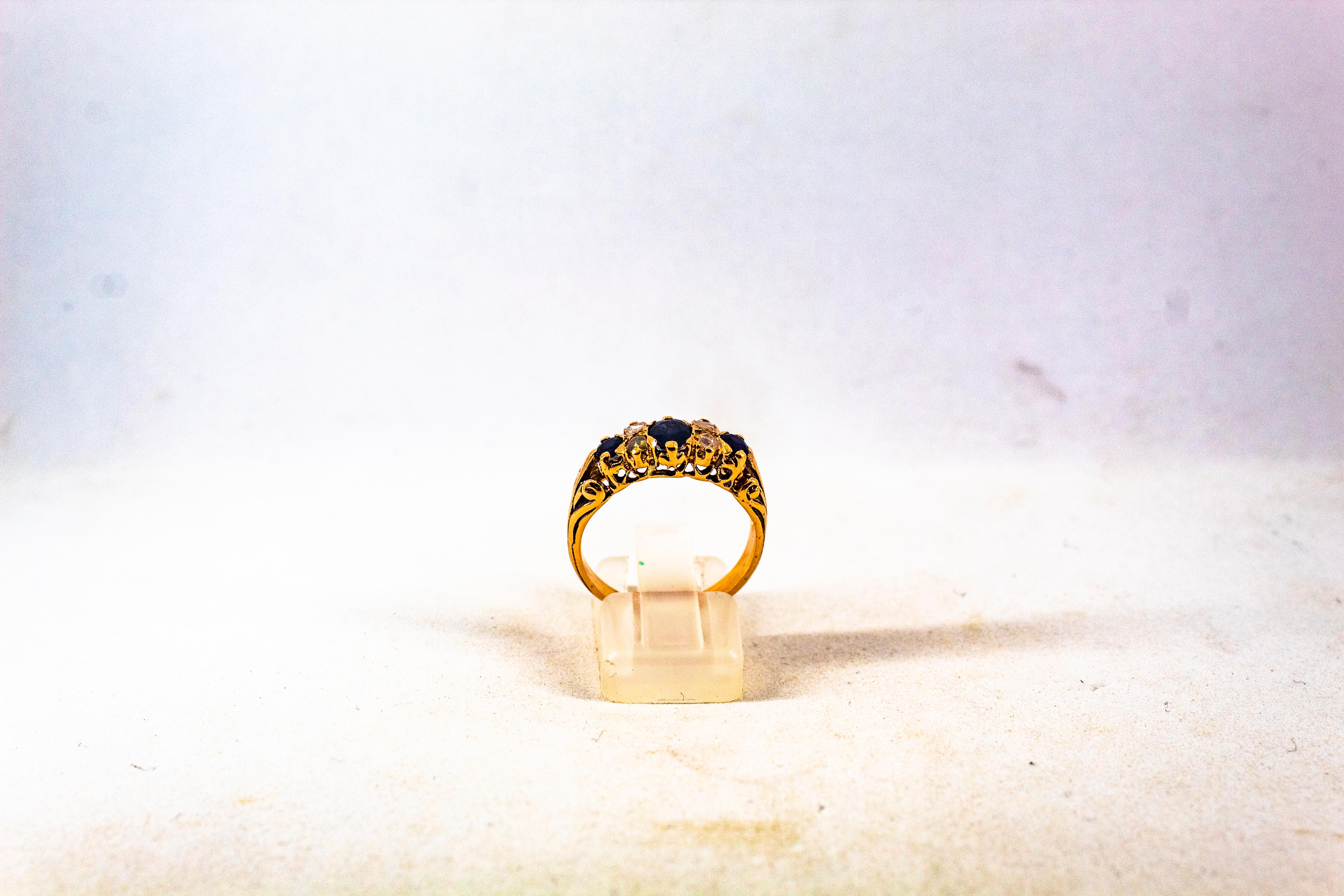 This Ring is made of 9K Yellow Gold.
This Ring has 0.15 Carats of White Rose Cut Diamonds.
This Ring has 0.60 Carats of Oval Cut Blue Sapphires.

This Ring is available also in 14 or 18K Yellow or White Gold.
This Ring is available also with Rubies