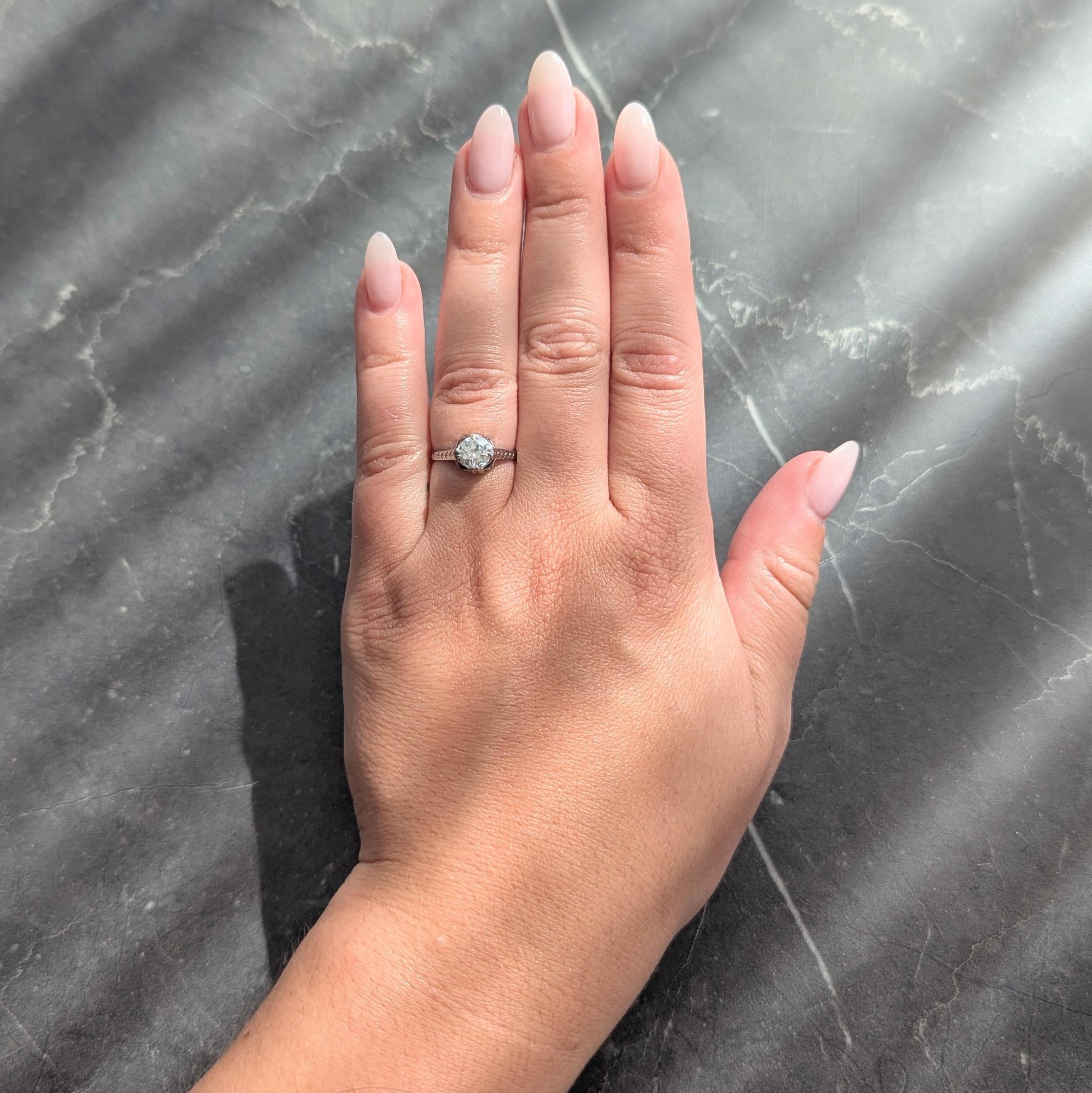 In der Mitte ein Diamant im Übergangsschliff mit einem Gewicht von etwa 0,75 Karat - Farbe K und Reinheit SI1
Mit geteilten Zacken und einem eingravierten Weizenmotiv an den Schultern
Akzentuiert mit synthetischen Saphiren im Kaliberschliff -