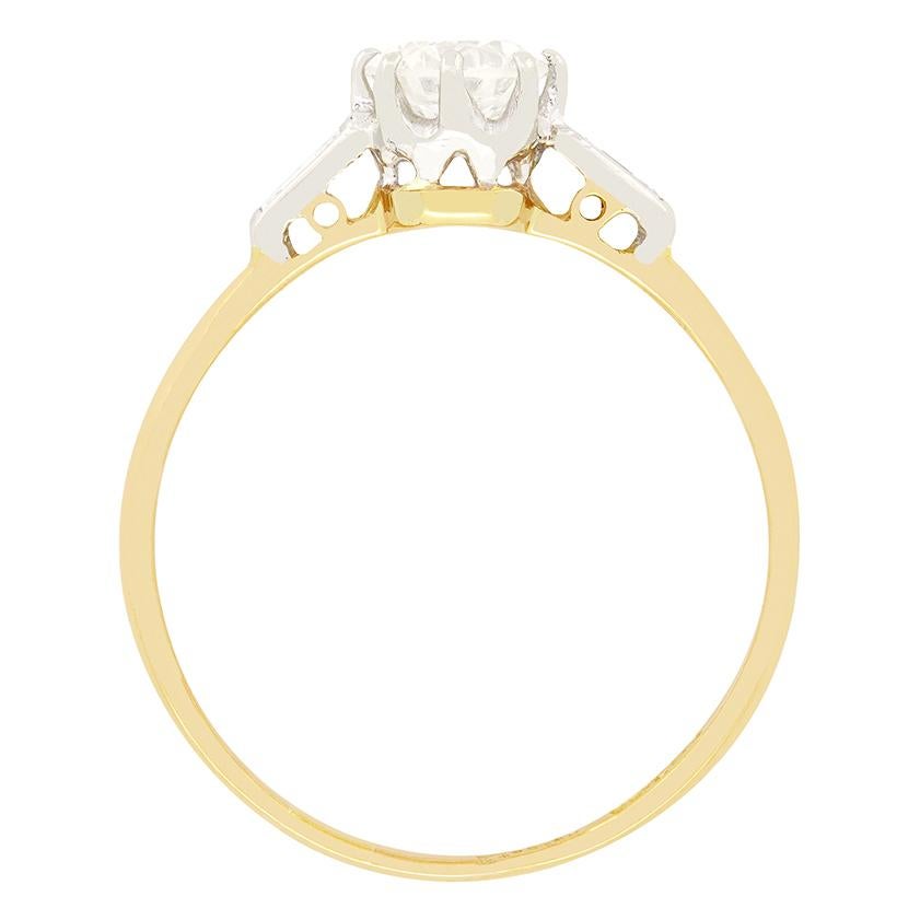 A 0.75 carat old cut diamond sits central to this beautiful Art Deco solitaire ring. The claw set diamond has a colour of I and clarity of VS1. The platinum collet flows down into shoulders of the same metal where an additional two baguette cut