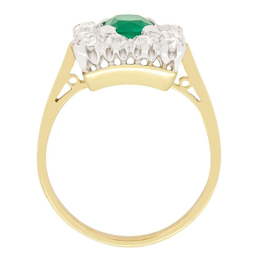 A vibrant 0.75 carat emerald sits central in this Art Deco square cluster ring. The beautiful green gem is an emerald cut stone, claw set into platinum. Around the emerald is set a total of 0.60 carat in old cut diamonds. Each diamond matches in