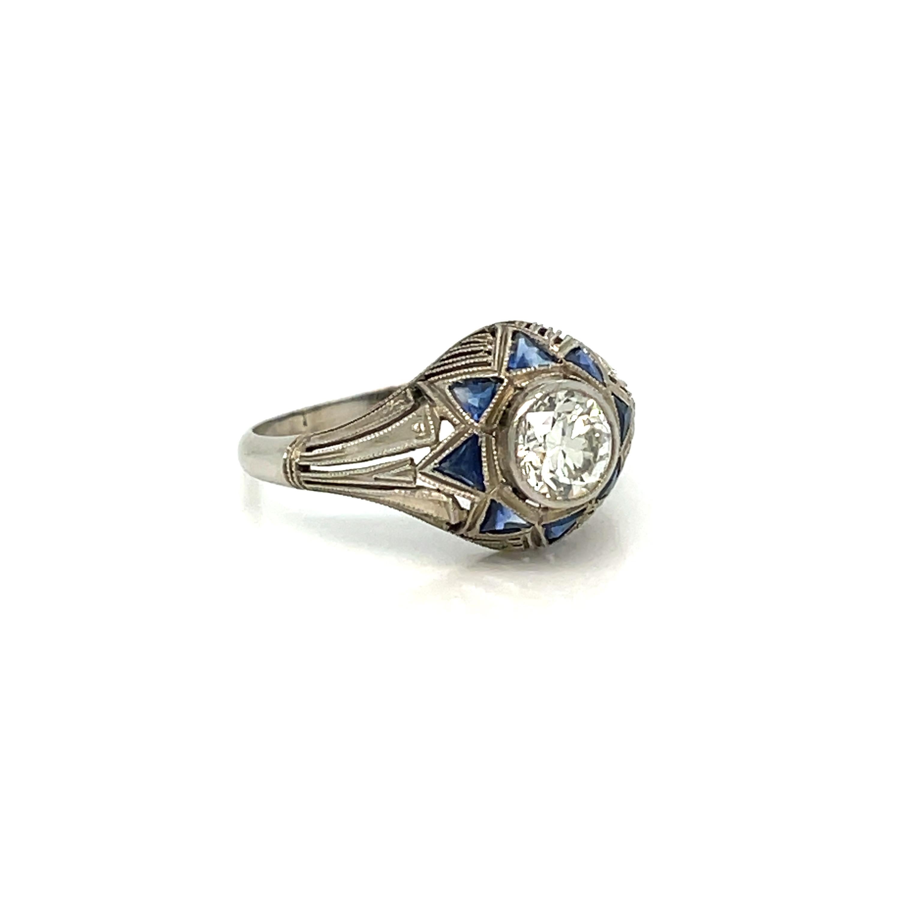 Bellissimo anello Art Deco in oro fatto a mano.
È incastonato in oro bianco 18 carati con un grande diamante scintillante di taglio Vecchio Europeo, del peso totale di 0,80 ct. Colore H, purezza VS2, circondato da uno zaffiro naturale con taglio