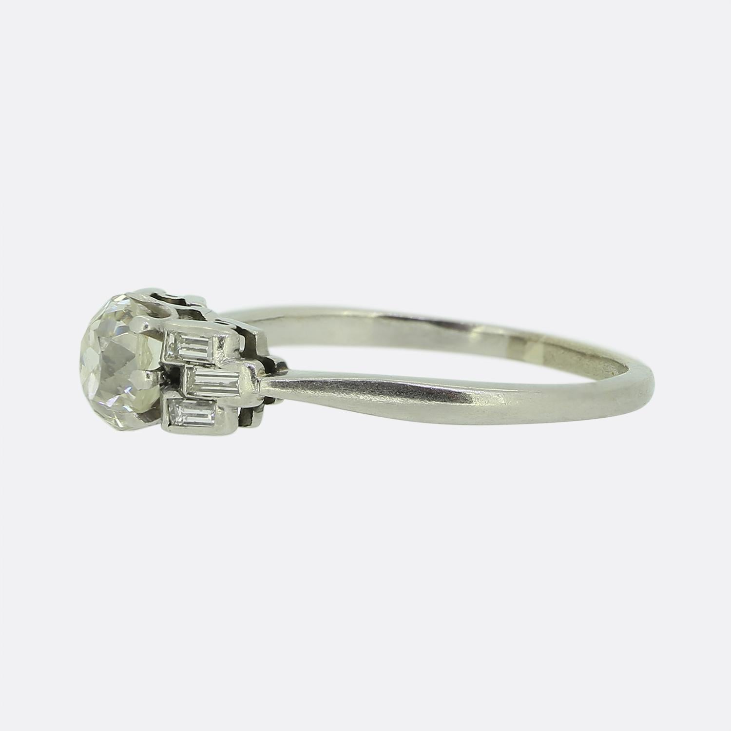 Here we have a charming diamond ring dating back to the early stages of the 20th century. This antique piece features a chunky 0.80 carat old mine cut diamond at the centre of the face. This principal stone sits slightly risen in a 6 clawed setting