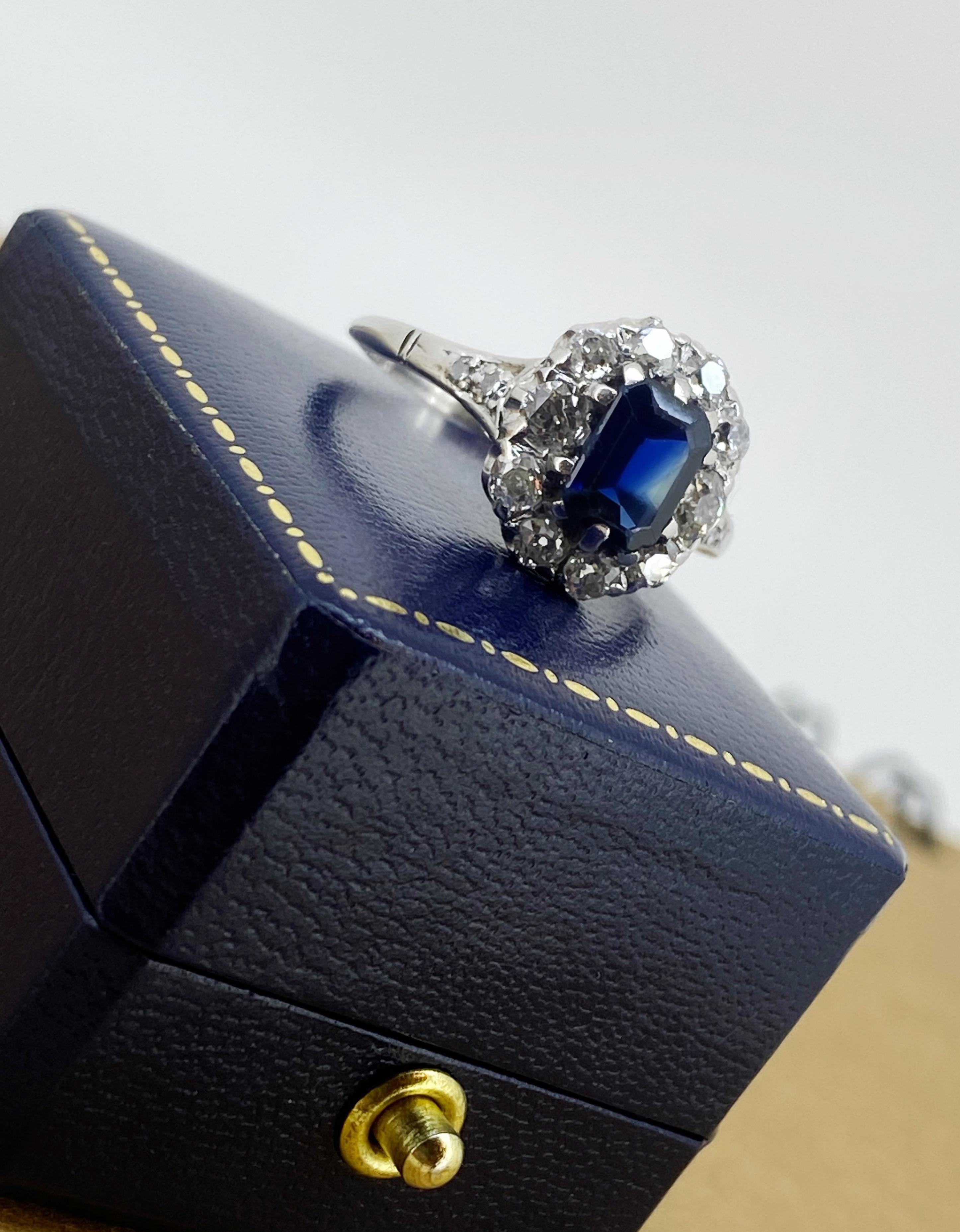 Mit zeitlosem und kultigem Prinzessin-Diana-Design,  
dieser Art-Deco-Ring ist aus 18 Karat Weißgold und Platin gefertigt  

In der Mitte ein prächtiger natürlicher Saphir
des begehrten Smaragdschliffs,
australischer Herkunft, 
von prächtiger,