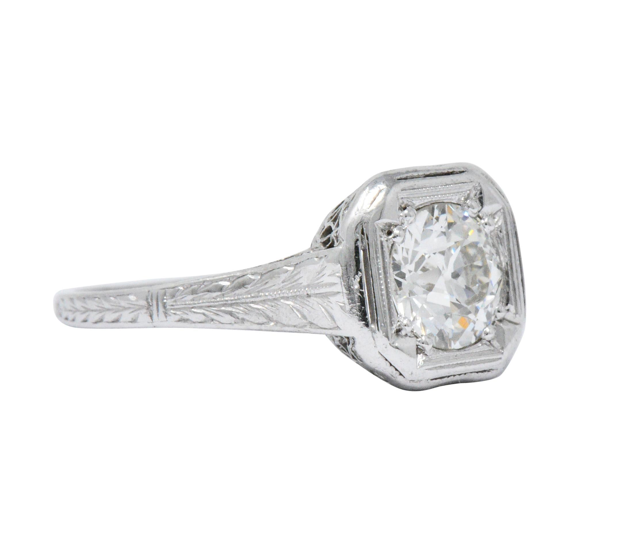 Centering an old European cut diamond weighing approximately 0.87 carat, I color with VS2 clarity

Set low in cushion shaped mounting featuring a Maltese cross motif setting

With cathedral style shoulders, deeply engraved with wheat foliate motif,