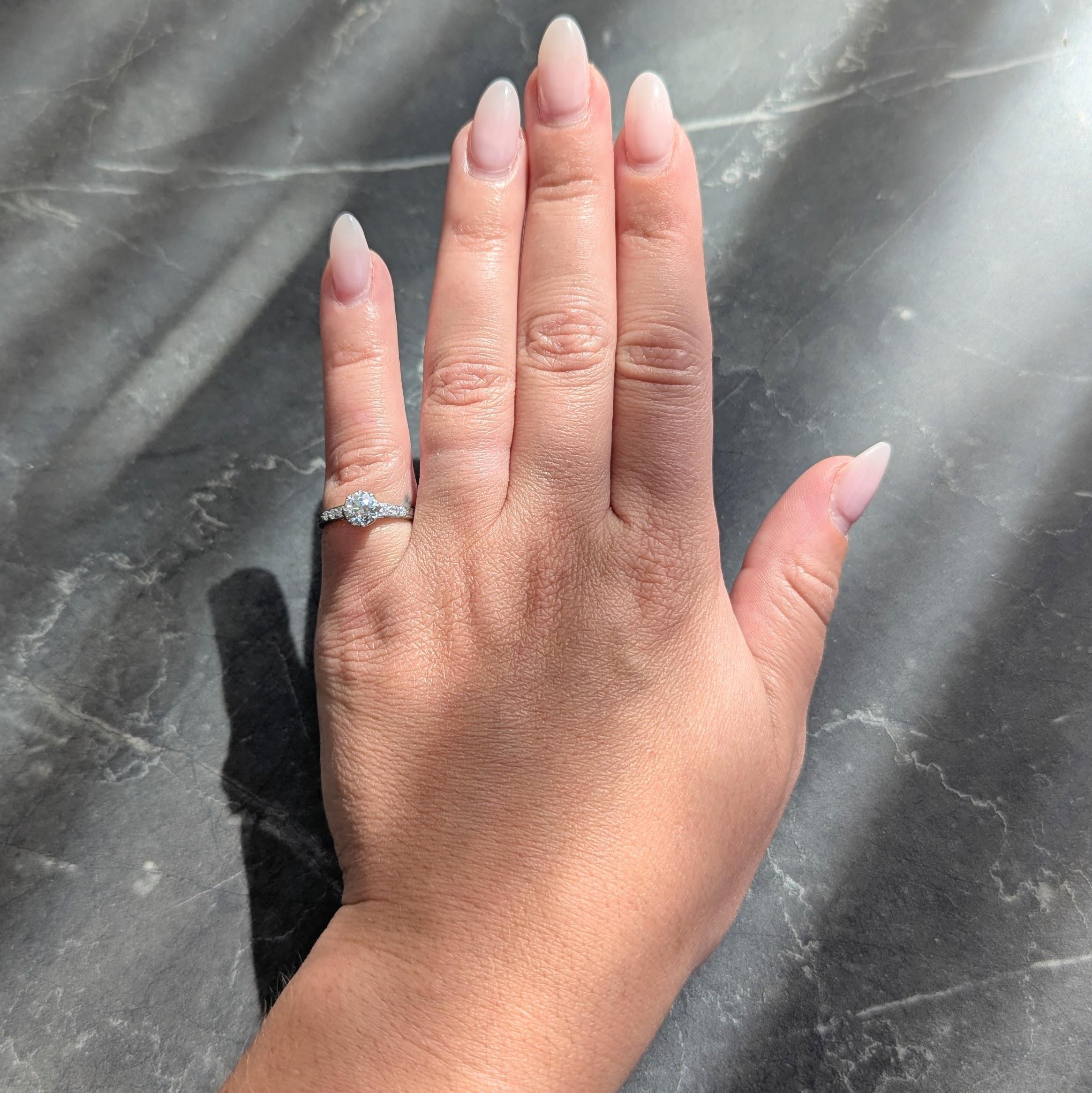 Al centro un diamante vecchio taglio europeo del peso di circa 0.72 carati
Colore I con purezza VS2 - incastonato con punte di talon in una galleria decorosamente forata
Affiancato da spalle geometriche a cattedrale con diamanti singoli