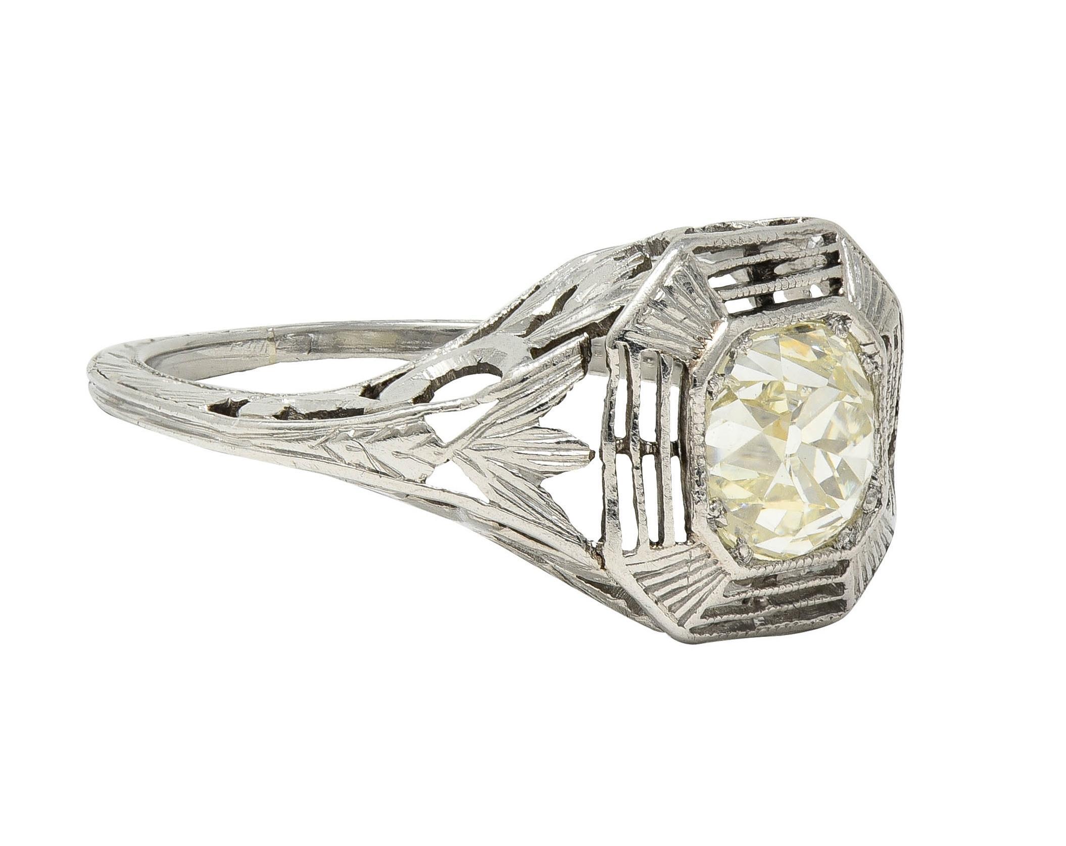 Centering an old mine cut diamond weighing approximately 0.87 carat - M/N color with VS2 clarity 
Bead set in an octagonal form head decorated with pierced striated details and fanning stations
Featuring pierced lotus motif shoulders and gallery