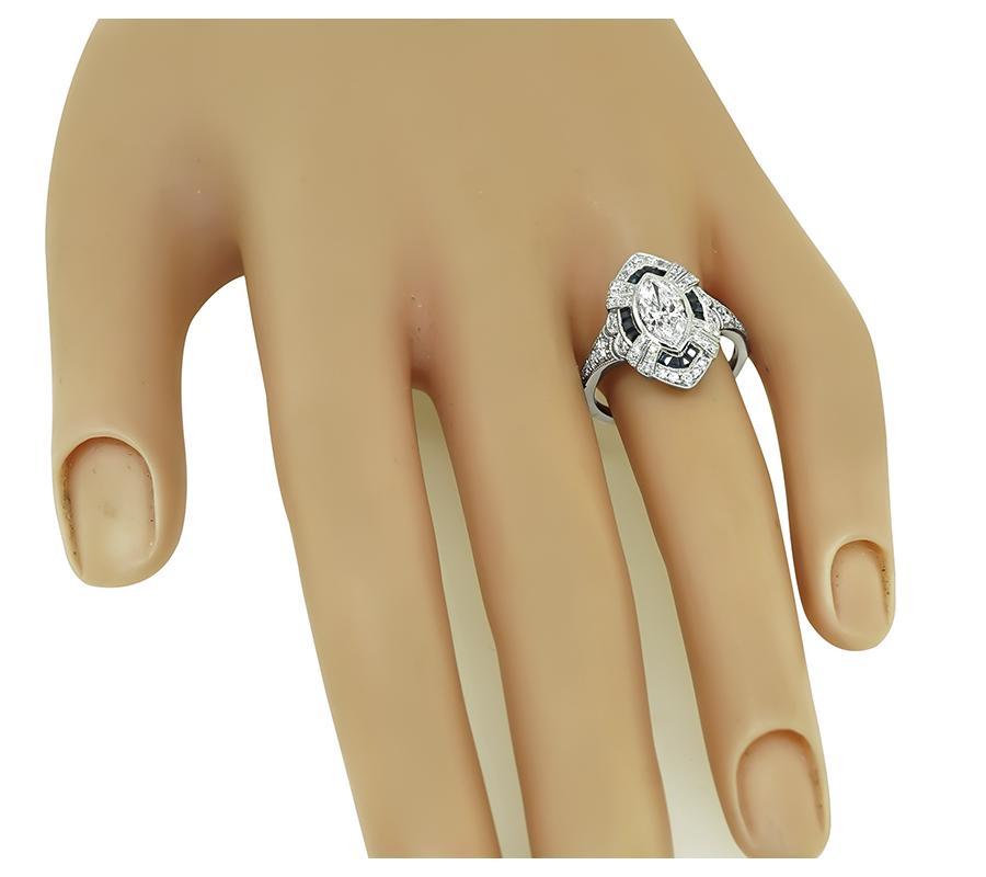 This is a charming platinum ring from the Art Deco era. The ring is centered with sparkling marquise cut diamond that weighs approximately 0.89ct. The color of the diamond is E-F with SI2 clarity. The center diamond is accentuated by dazzling round
