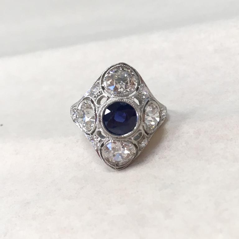 Real Art Deco round blue sapphire and Platinum diamond ring.

Handmade.
1 round blue sapphire  5.50 x 3.90mm   (approx.:  0.90ct)
4 old European cut diamonds, clarity SI, color H   (approx.: 1.84ct)
6 old European cut diamonds, clarity SI, color H  