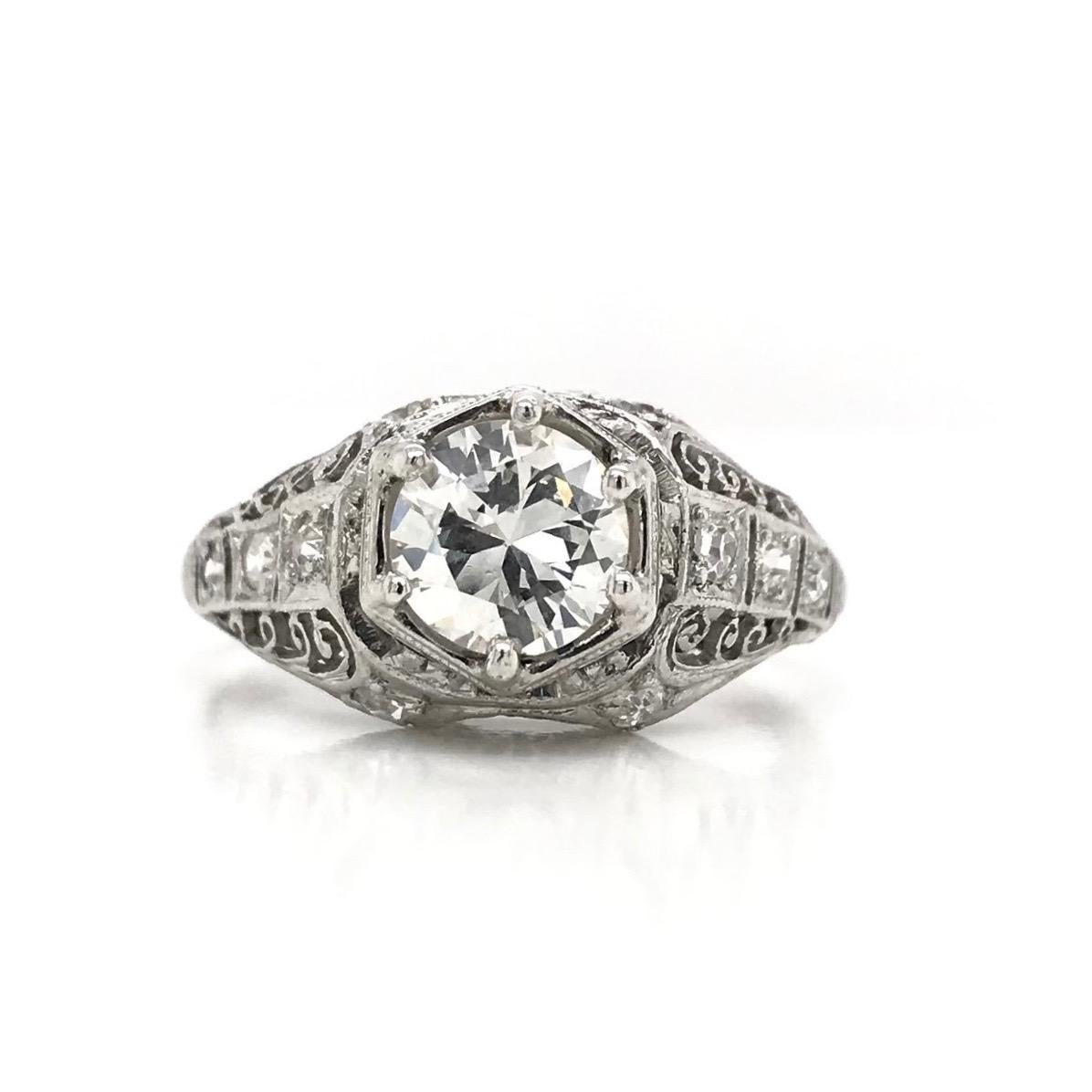 This antique piece was handcrafted sometime during the Art Deco design period ( 1920-1940 ). The beautiful filigree setting is platinum and features a 0.93 carat center diamond. The center Old European Cut diamond grades approximately K in color,