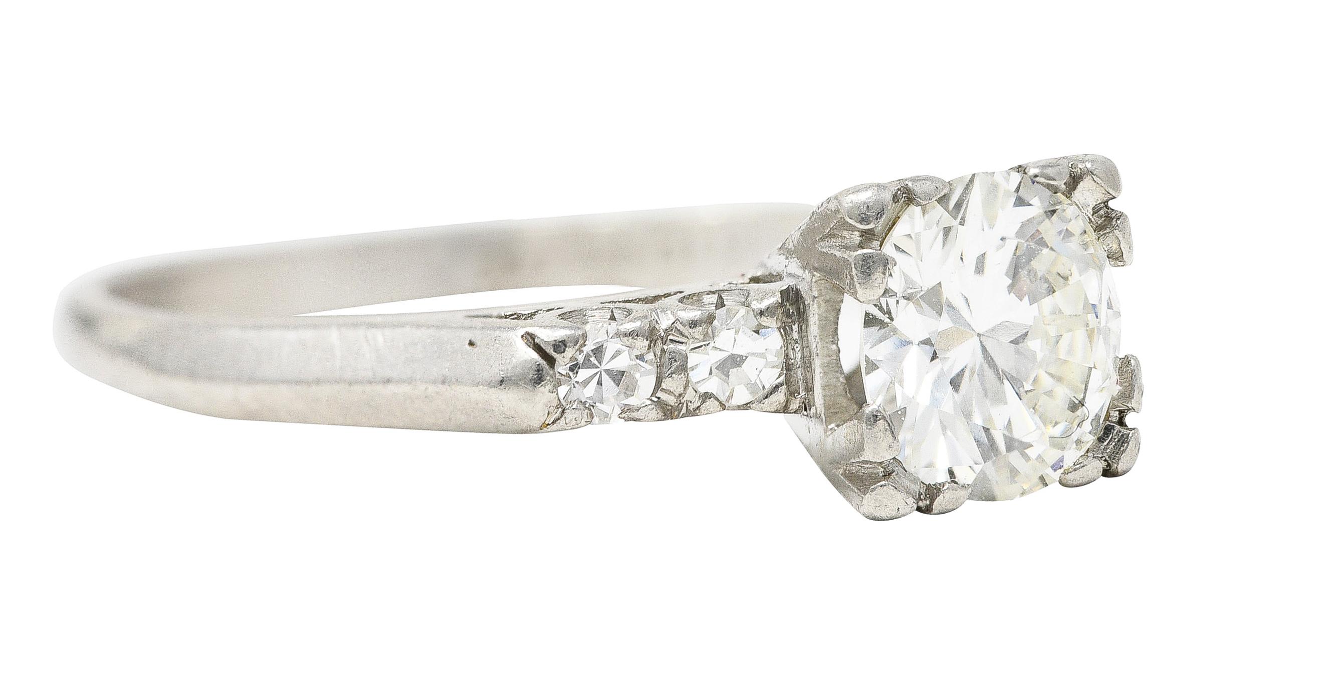 Centering a transitional cut diamond weighing approximately 0.80 carat total - H color with VS2 clarity. Set with tri-split prongs in a pierced square form basket and flanked by single cut diamonds. Prong set and weighing approximately 0.16 carat