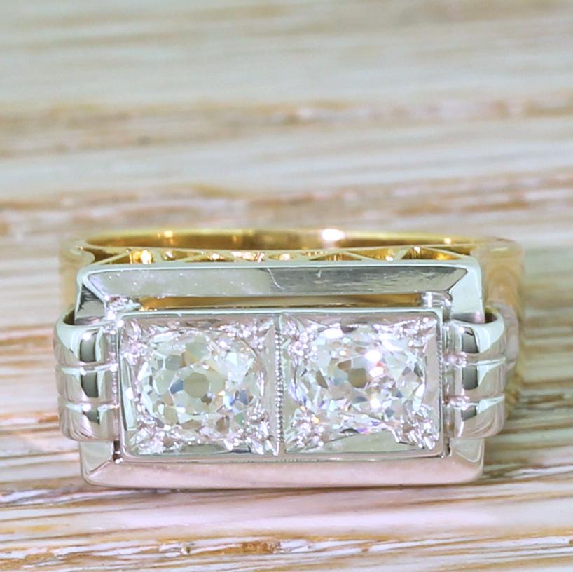 An absolutely glorious Art Deco diamond ring. A pair of matching old mine cut diamonds – both dazzlingly white and internally clean – are set side by side in a geometric settings, with fine triangular detailing in the gallery. Sweeping white gold