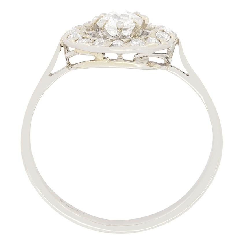 Crafted by hand in the 1920s this beautifully unique cluster ring features a 0.50 carat old cut diamond at its centre. The claw setting work is made from platinum, to really show off the whiteness of the high quality, G colour and VS2 clarity