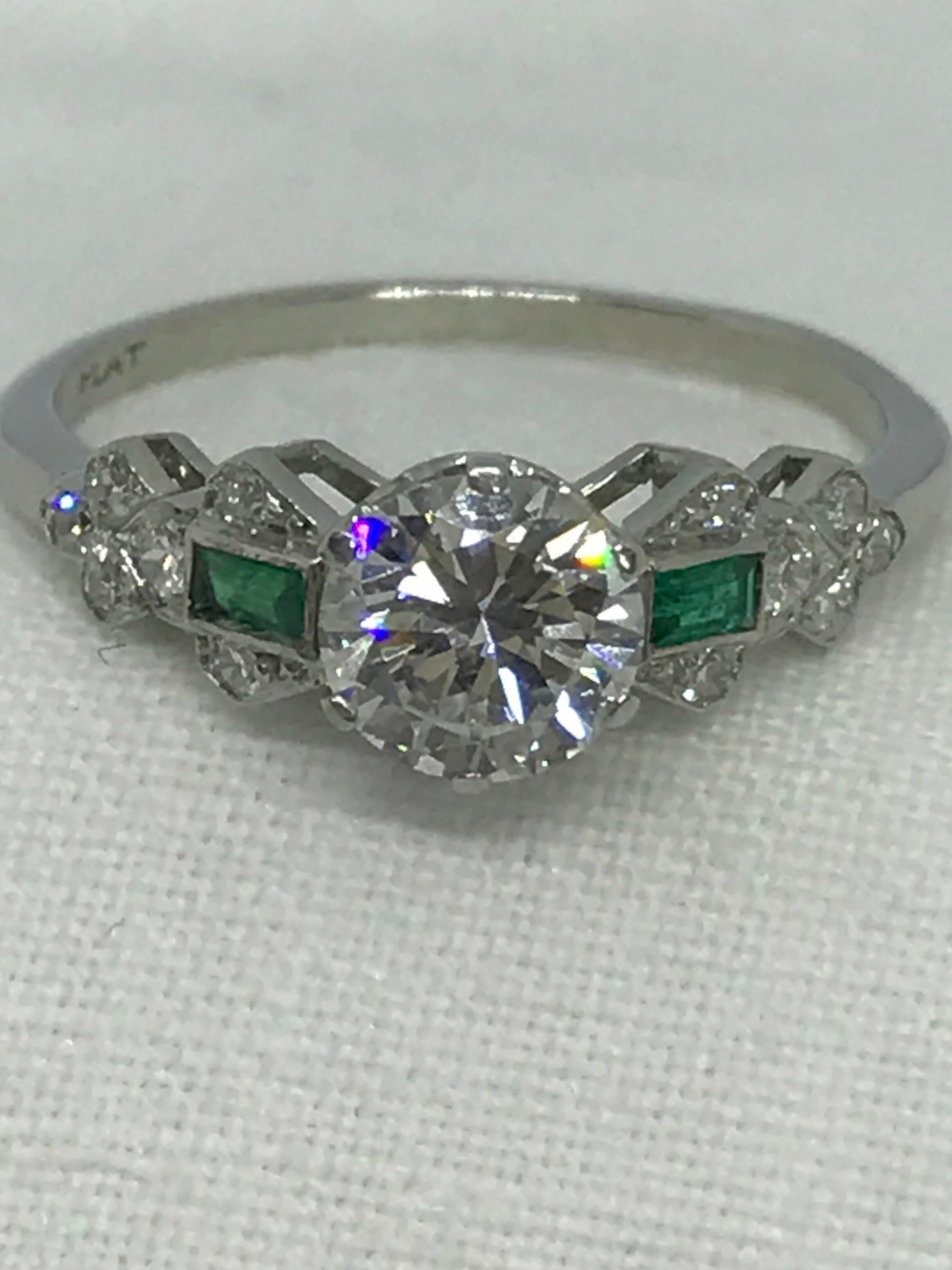 A diamond and emerald art deco ring, high art deco with geometric shoulders set with two baguette emeralds - circa 1940. The shank is marked platinum on the inside.  The diamond is VS2 and E/F colour it has great fire and sparkle.  This would make a