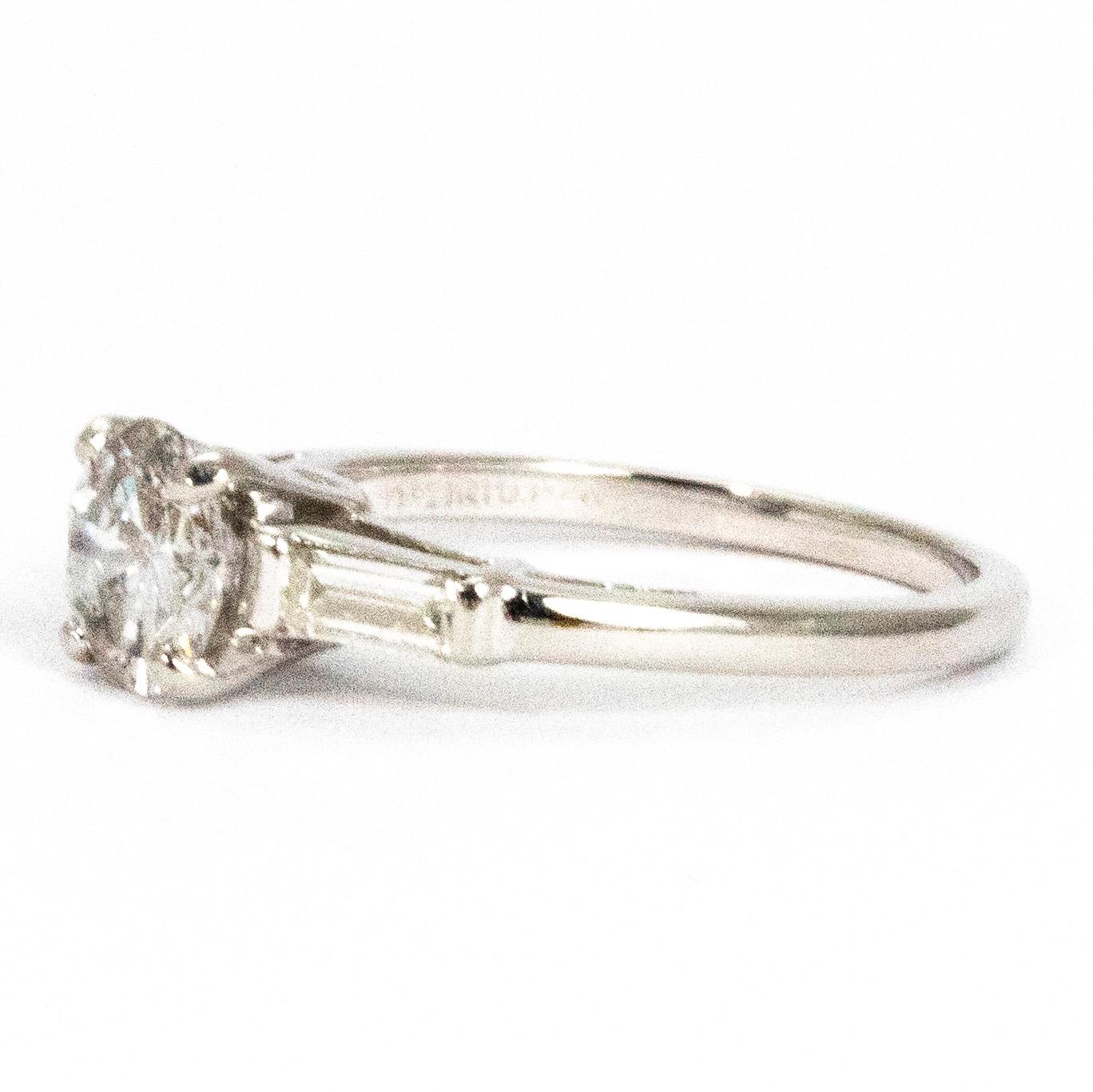 This gorgeous ring features a centre diamond which measures approximately 1carat and wither side of this stone there sits a baguette diamond. The centre stone is an H colour SI 1. The ring sits at a lovely height on the finger an the diamonds have a