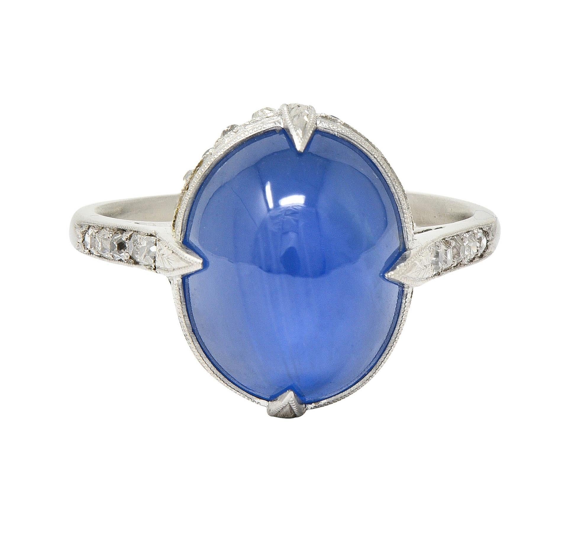 Centering an oval-shaped sapphire cabochon weighing 9.70 carats - transparent medium blue
Natural Ceylon in origin with no indications of heat treatment - displaying six-point asterism
Set with engraved foliate motif talon prongs and orange blossom