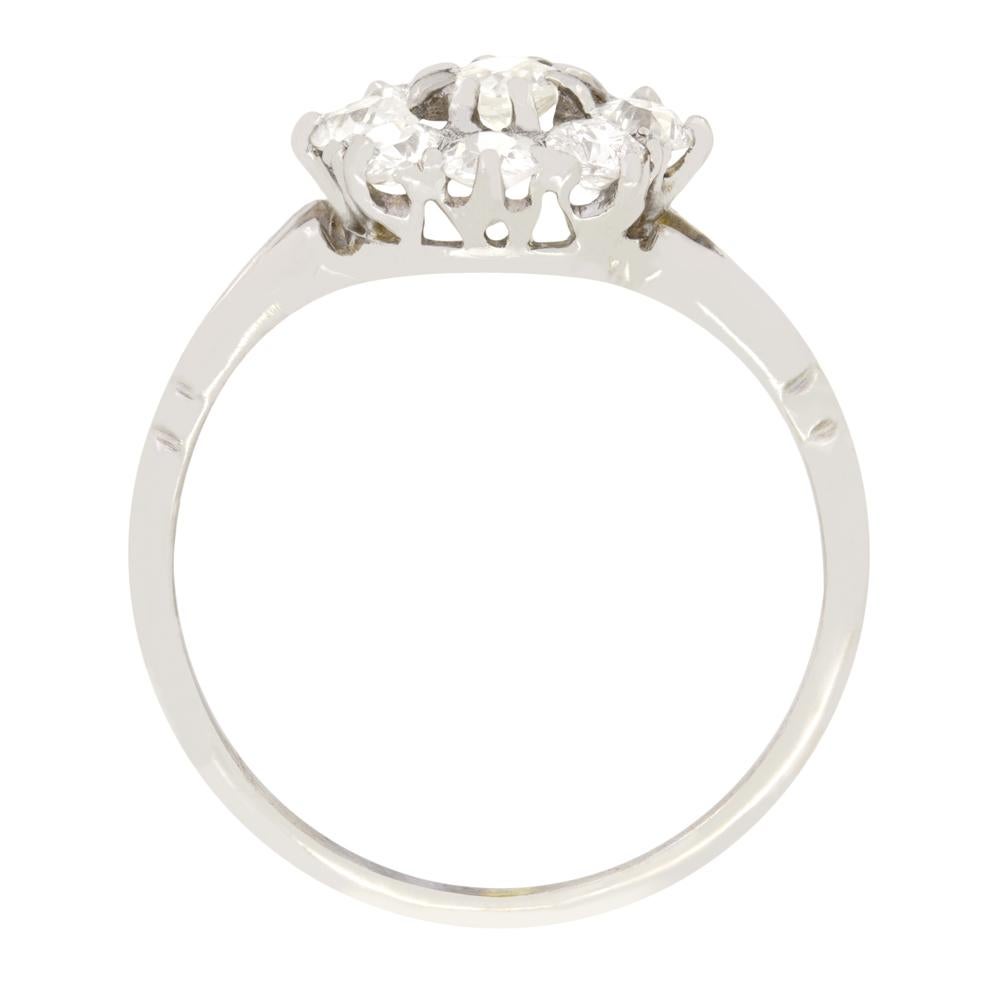 This wonderful daisy cluster ring was hand crafted during the Art Deco period. A slightly raised central 0.20 carat diamond is surrounded by eight 0.10 carat stones for a total of 1.00 carat. Each diamond is an old cut with a colour ranging from H