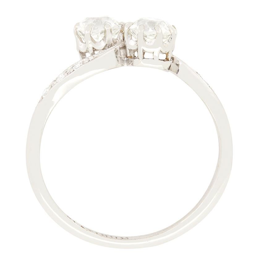 A pair of old cut diamonds share the spotlight in this delightful Art Deco twist ring. The duo match in size at 0.50 carat with colour grading between G and H and clarity of VS. Claw set into platinum collets the central diamonds are then enveloped