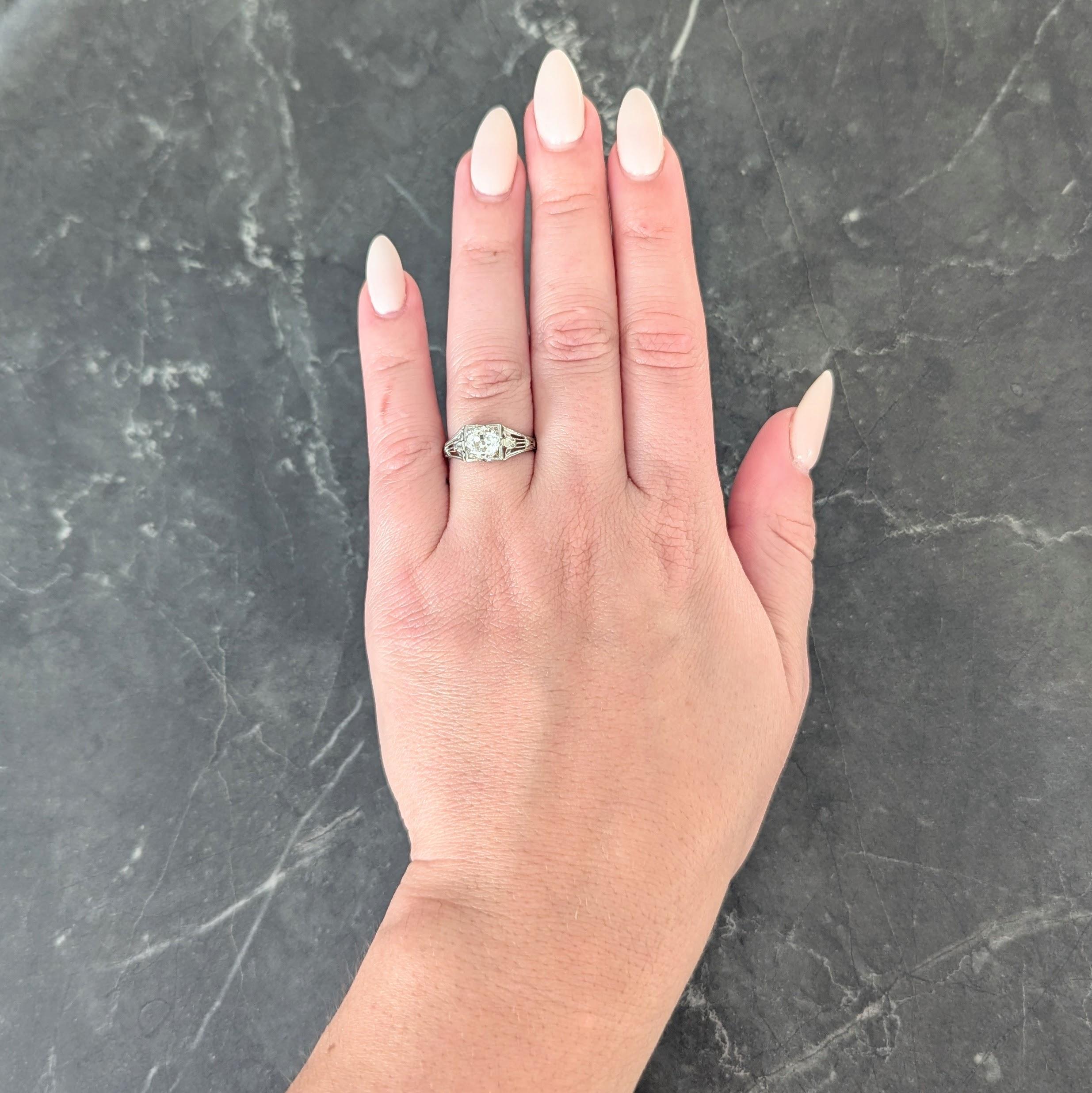 Centering an old European cut diamond weighing 1.02 carats - L color with SI1 clarity
Bead set in a stylized square form head with a pierced foliate motif gallery
Flanked by pierced lotus motif shoulder with milgrain detailing
Stamped for 18 karat