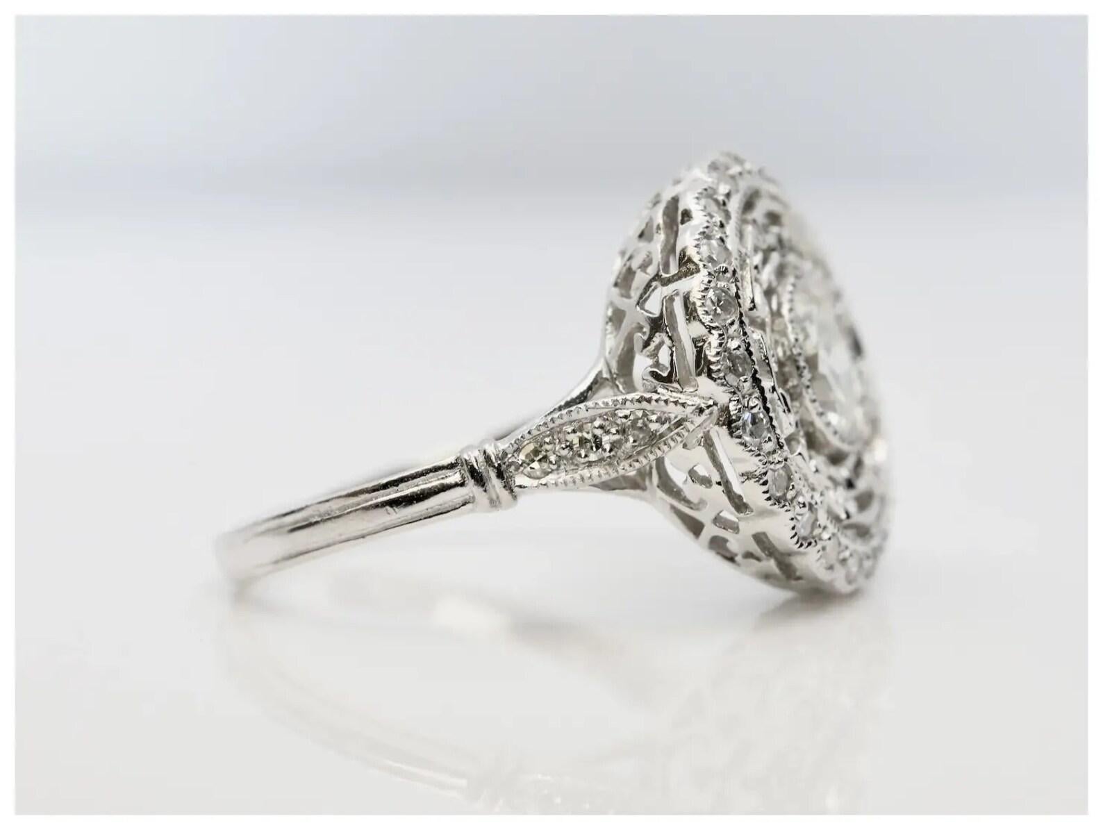 Ein diamantener Verlobungsring im Art-Déco-Stil, gefertigt aus Platin.

In der Mitte der Lünette befindet sich ein 0,74-karätiger Diamant im alten europäischen Schliff mit der Farbe I und der Reinheit VS1, eingefasst in eine