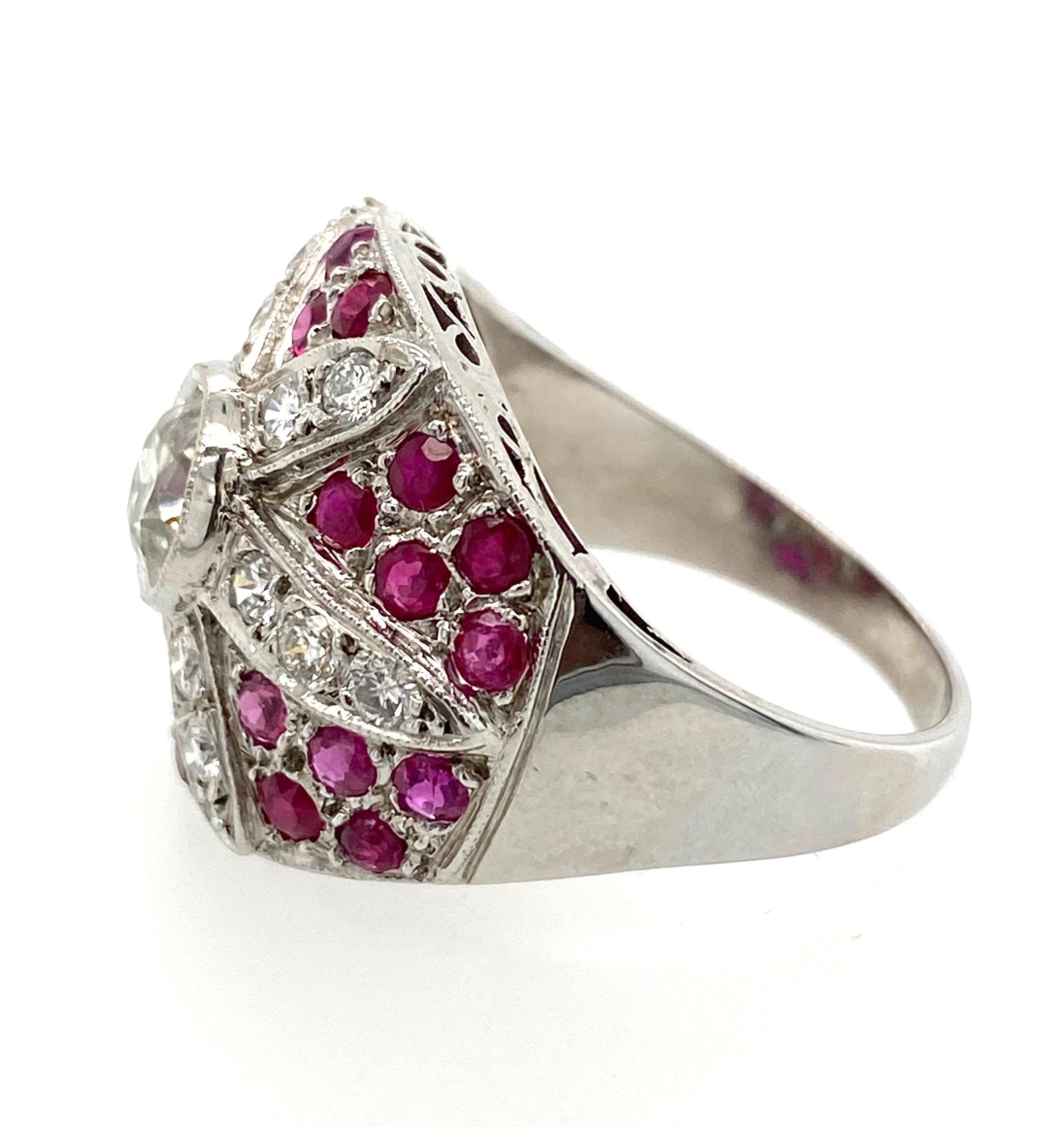 This Art Deco ring features a stunning 1.03 carat Old Mine Cut diamond at its center, which is surrounded by 1.15 carats of rich, red rubies. The platinum setting weighs 9.90 grams and is sized at 8, making it a substantial and impressive piece.The