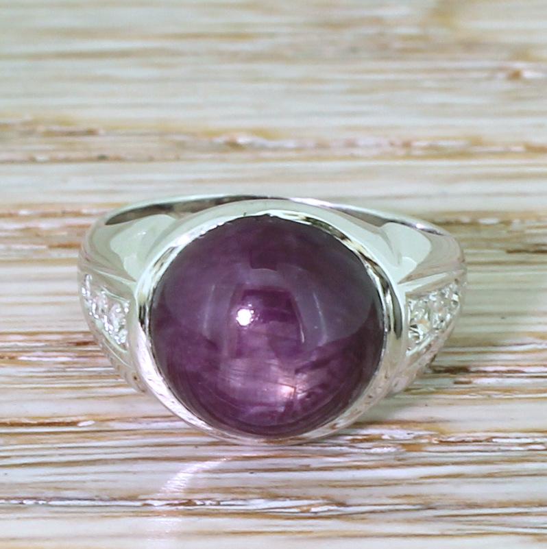 A fabulous vintage ruby ring. The round cabochon stone is a rich, purplish red with distinct flashes of light red as it catches the light. A sturdy white gold shank features six (three each side) old cut and eight cut diamonds in the shaped