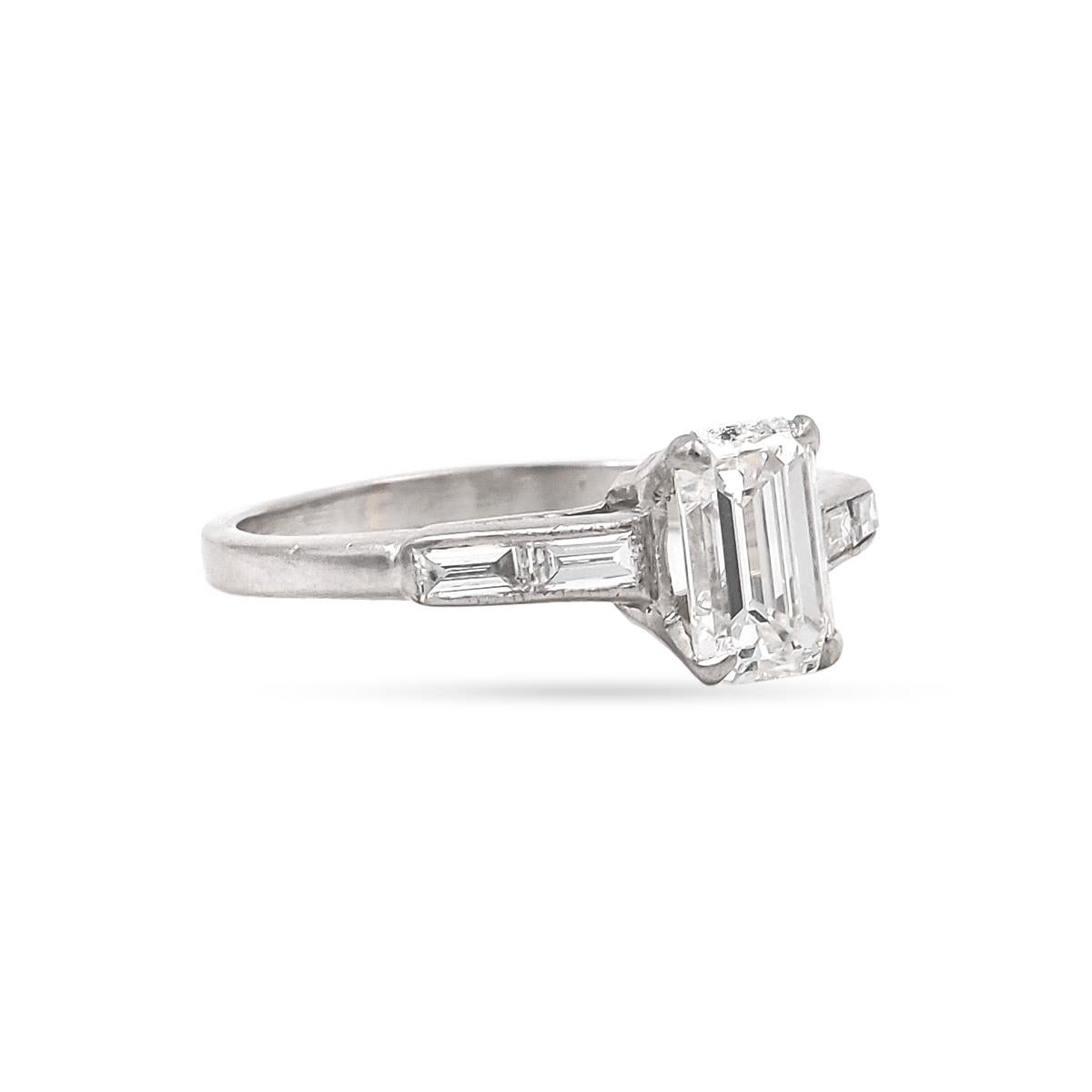 Art Deco era 1.05 Carat Emerald Cut Diamond Engagement Ring composed of platinum. GIA Certified G color/VS1 clarity. Flanked by 4 double-stacked Straight Baguette Cut diamonds on the shoulders, weighing approximately 0.24 carats in total. Circa