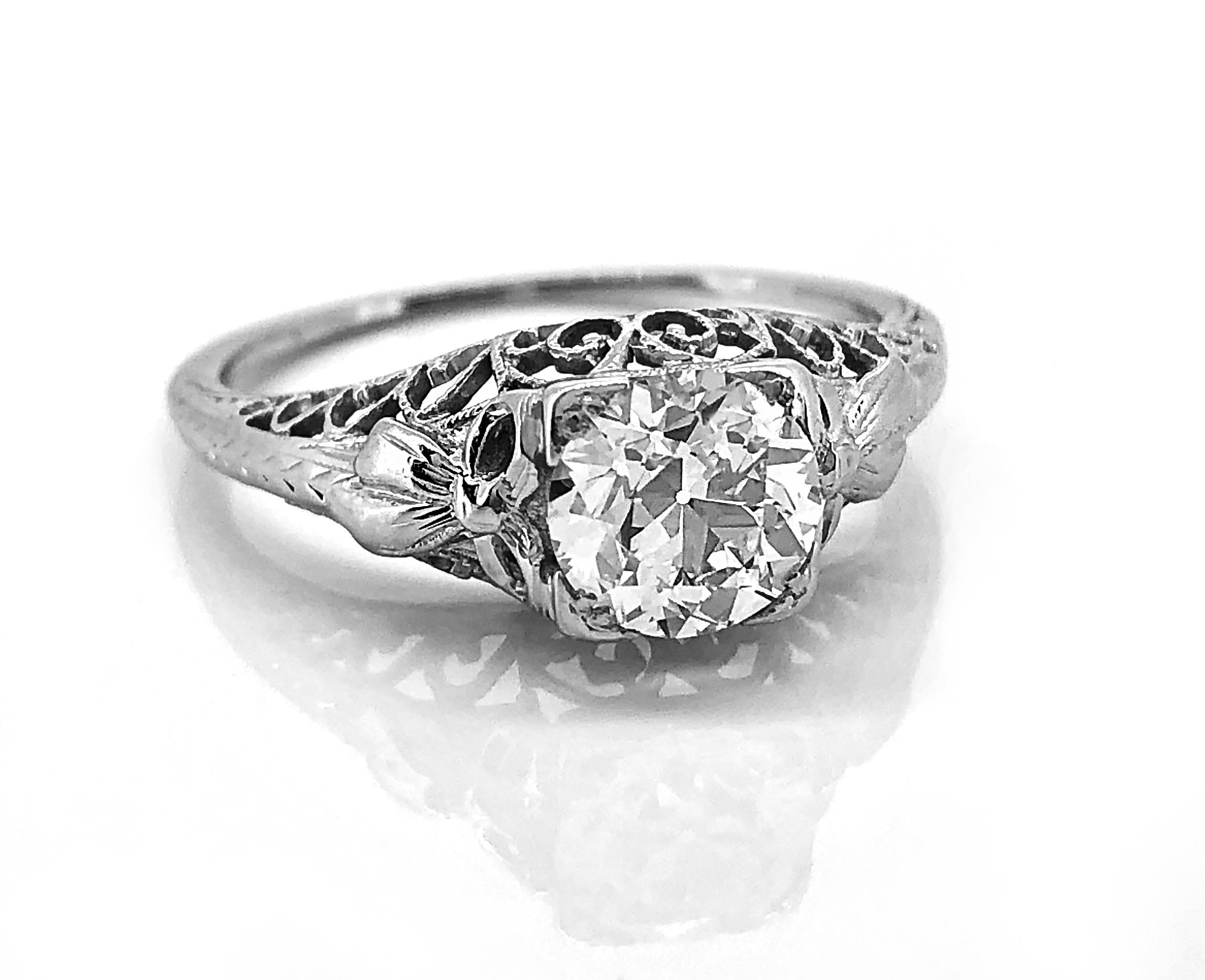 A decorative Edwardian diamond Antique engagement ring crafted in 18K white gold that features a 1.07ct. apx. European cut center diamond with VS2 clarity and H color. The mounting has been brilliantly filigreed and is also delicately engraved. This