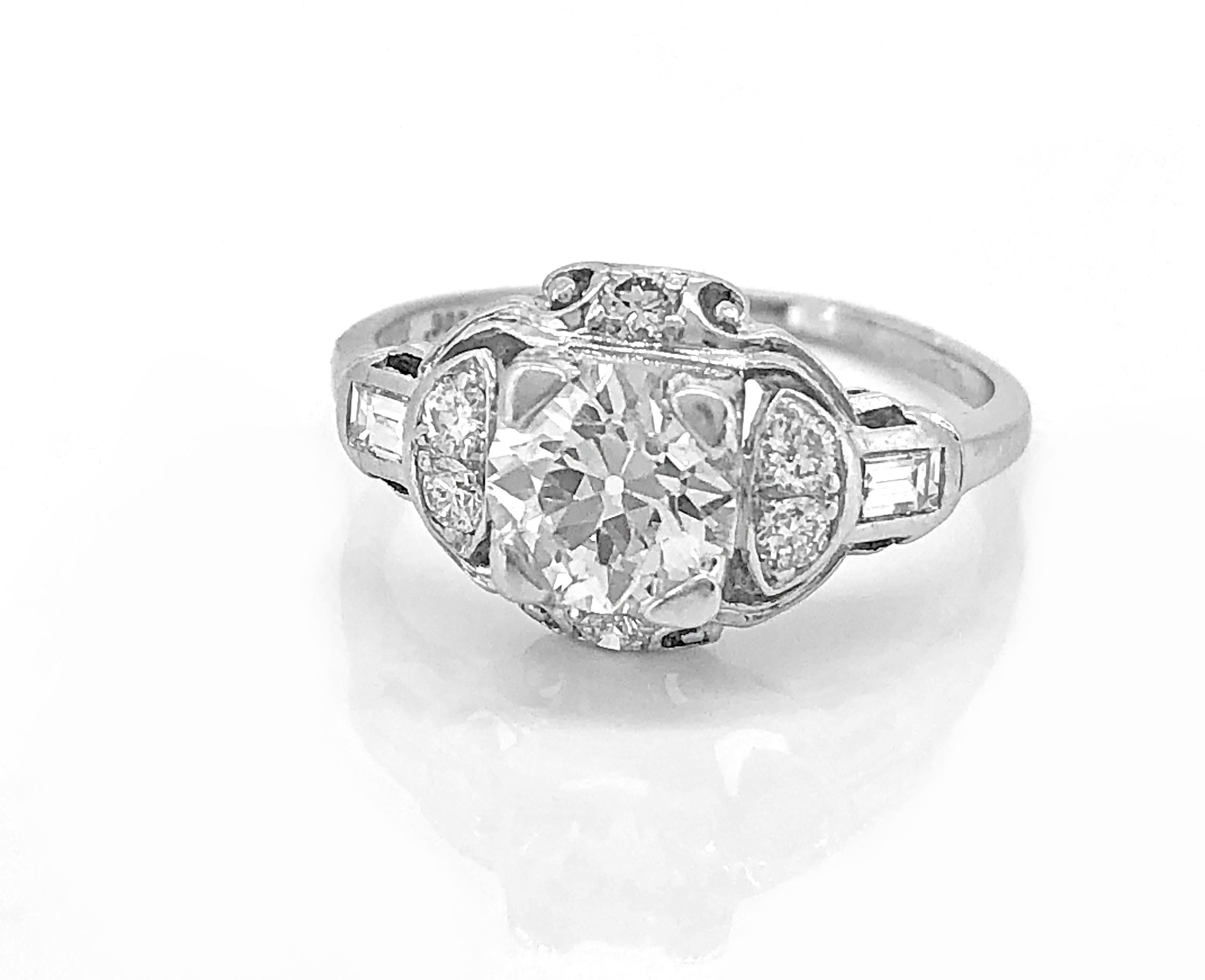 An incredible antique engagement ring crafted in platinum and features a 1.08ct. apx. European cut center diamond with VS2 clarity and H color. There are .25ct. apx. T.W. of baguette and transitional cut accenting diamonds. This ring is