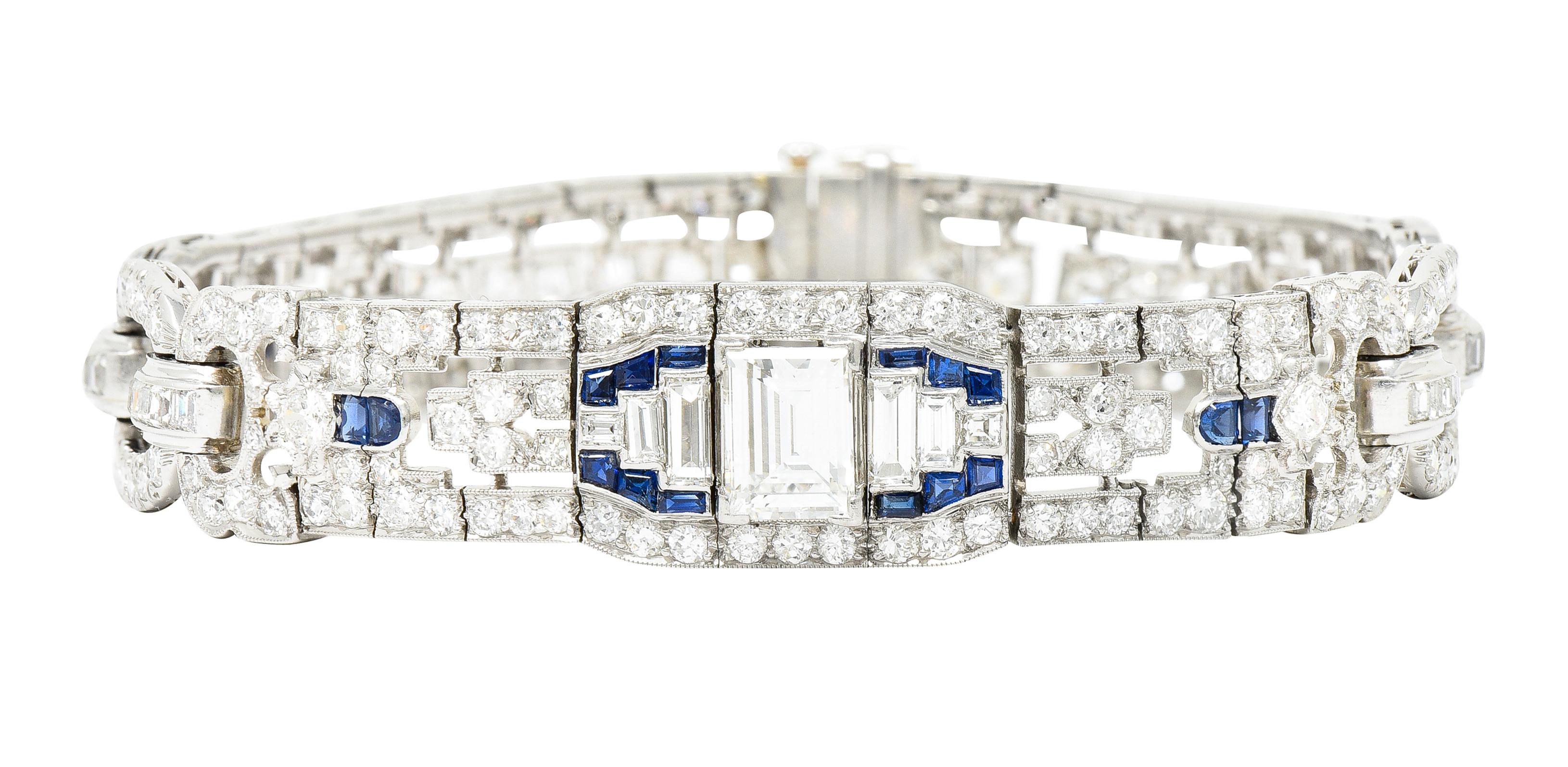 Comprised of hinged platinum link panels pierced with arrow motifs and alternating with oval links. Centering a baguette cut diamond weighing approximately 1.55 carats total - H color with VS clarity. Flanked by additional baguette cut diamonds