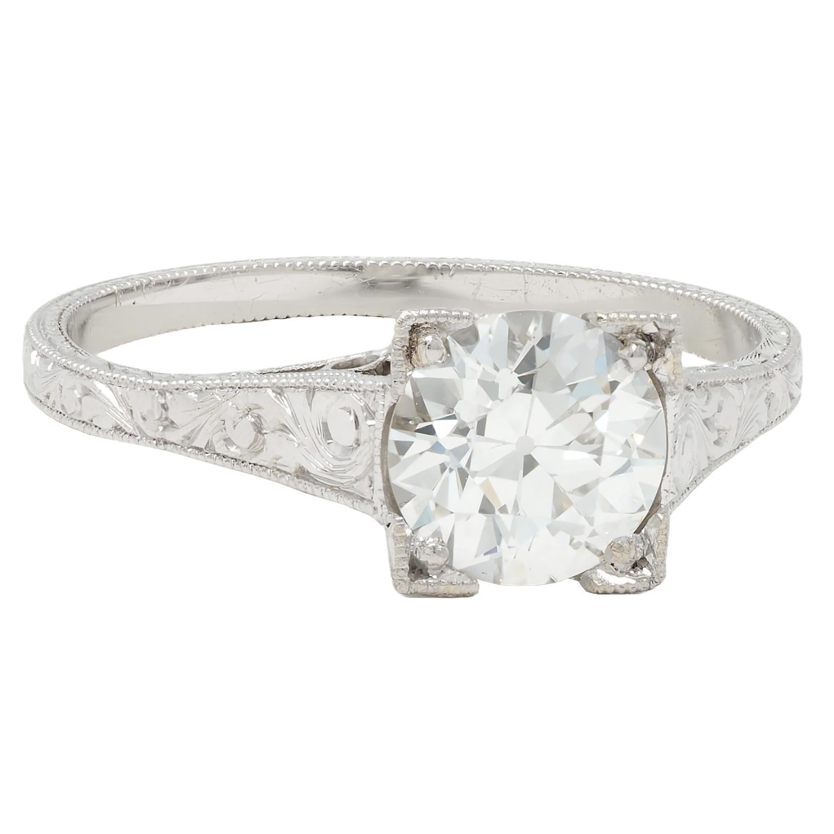 Centering an old European cut diamond weighing 1.09 carats - H color with VS1 clarity
Bead set in a square form basket ornately engraved with wheat and orange blossoms
Flanked by pierced geometric cathedral shoulders with milgrain detailing
Accented