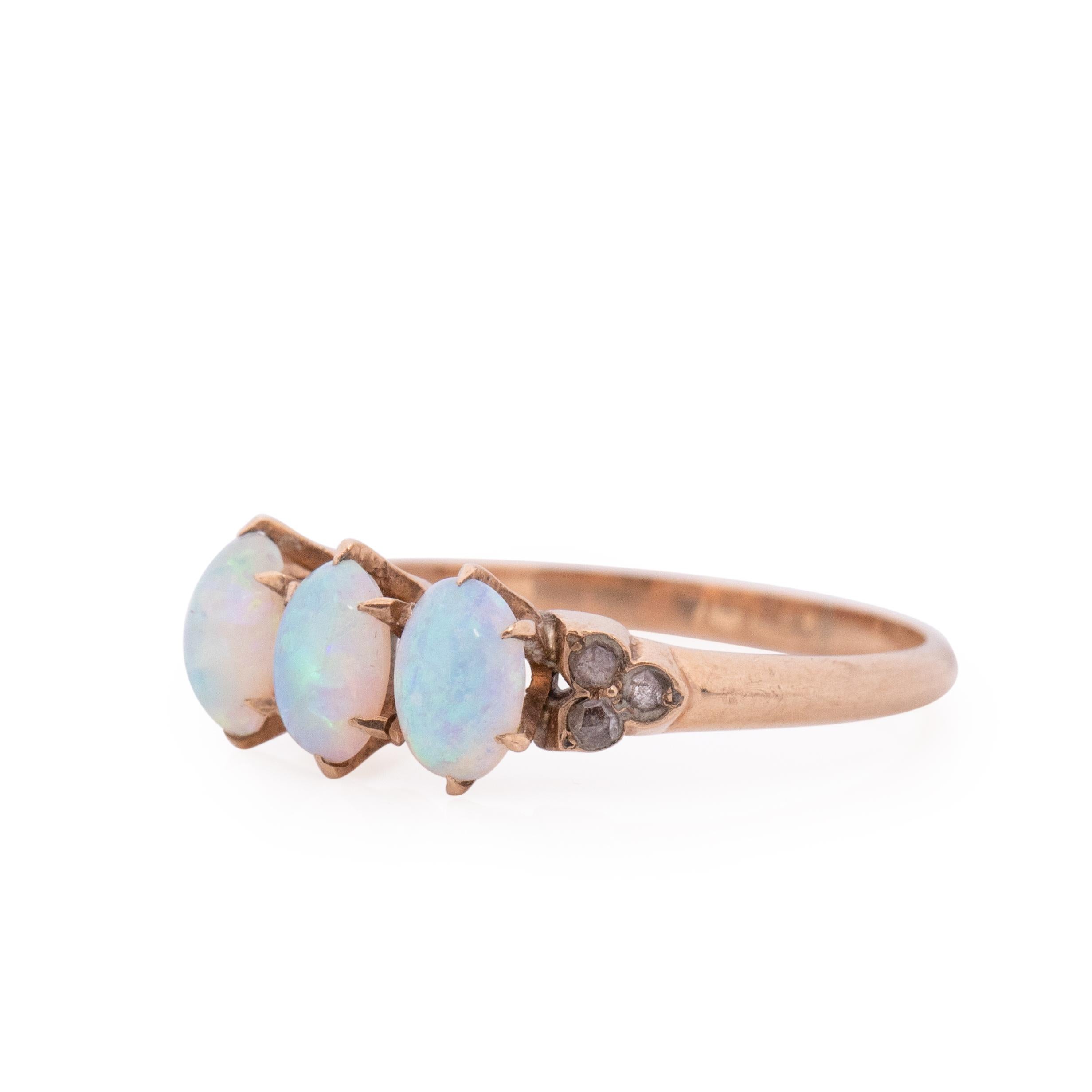 This ring is truly breath taking, every detail adds works in perfect harmony. This three stone ring is crafted in 10K rose gold, on either side of the three opals are diamonds in a tris shape. Giving it a floral feel. The three opals have