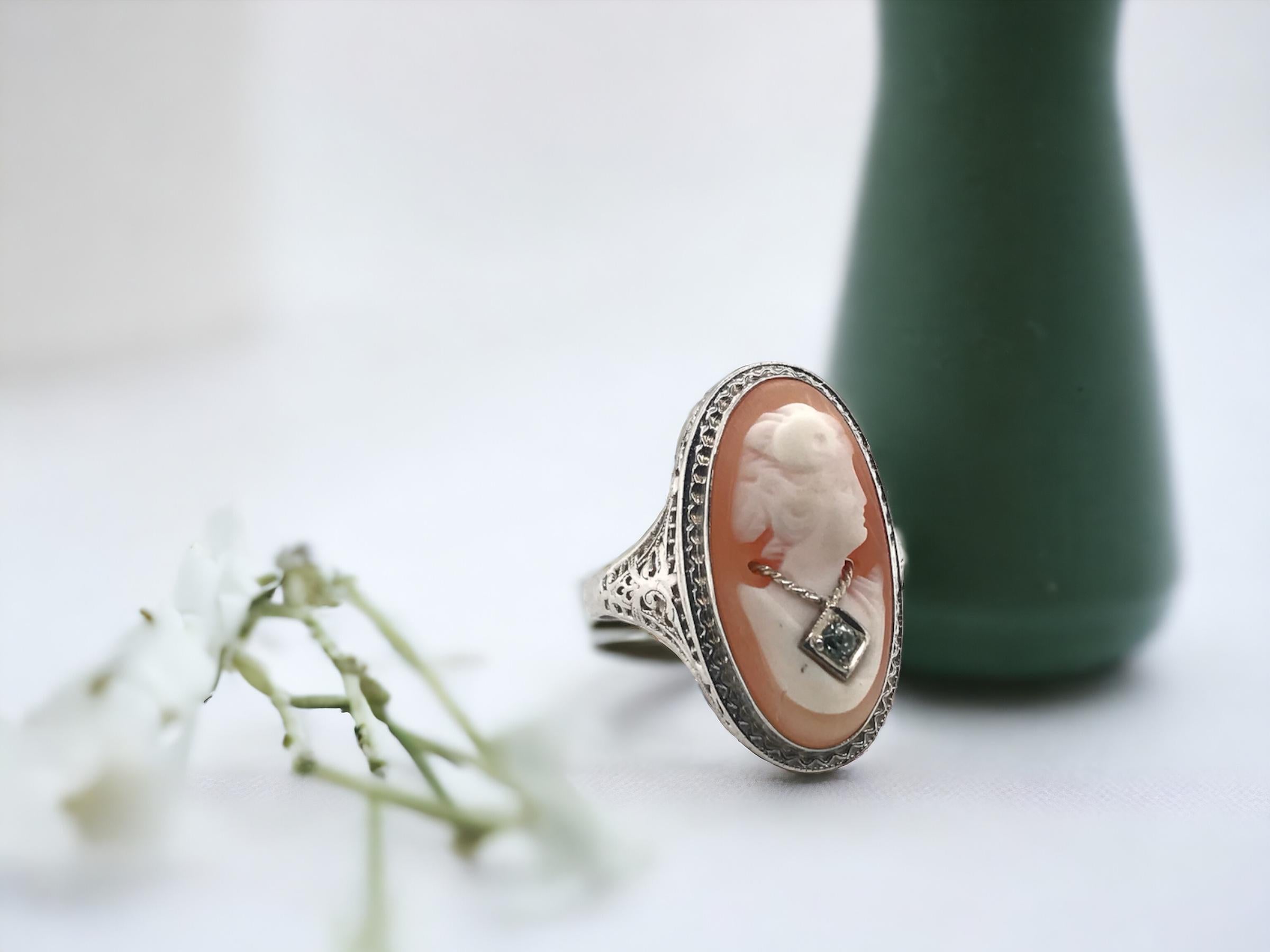 We always love vintage cameo rings like this.
This one is a little extra special as the model in the cameo is wearing a necklace!

Ring Details
Material: 10K White Gold
Era: Art Deco 1920 - 1940
Weight: 3.7 Grams
Length: 22.4mm
Width: 12.6mm
Height:
