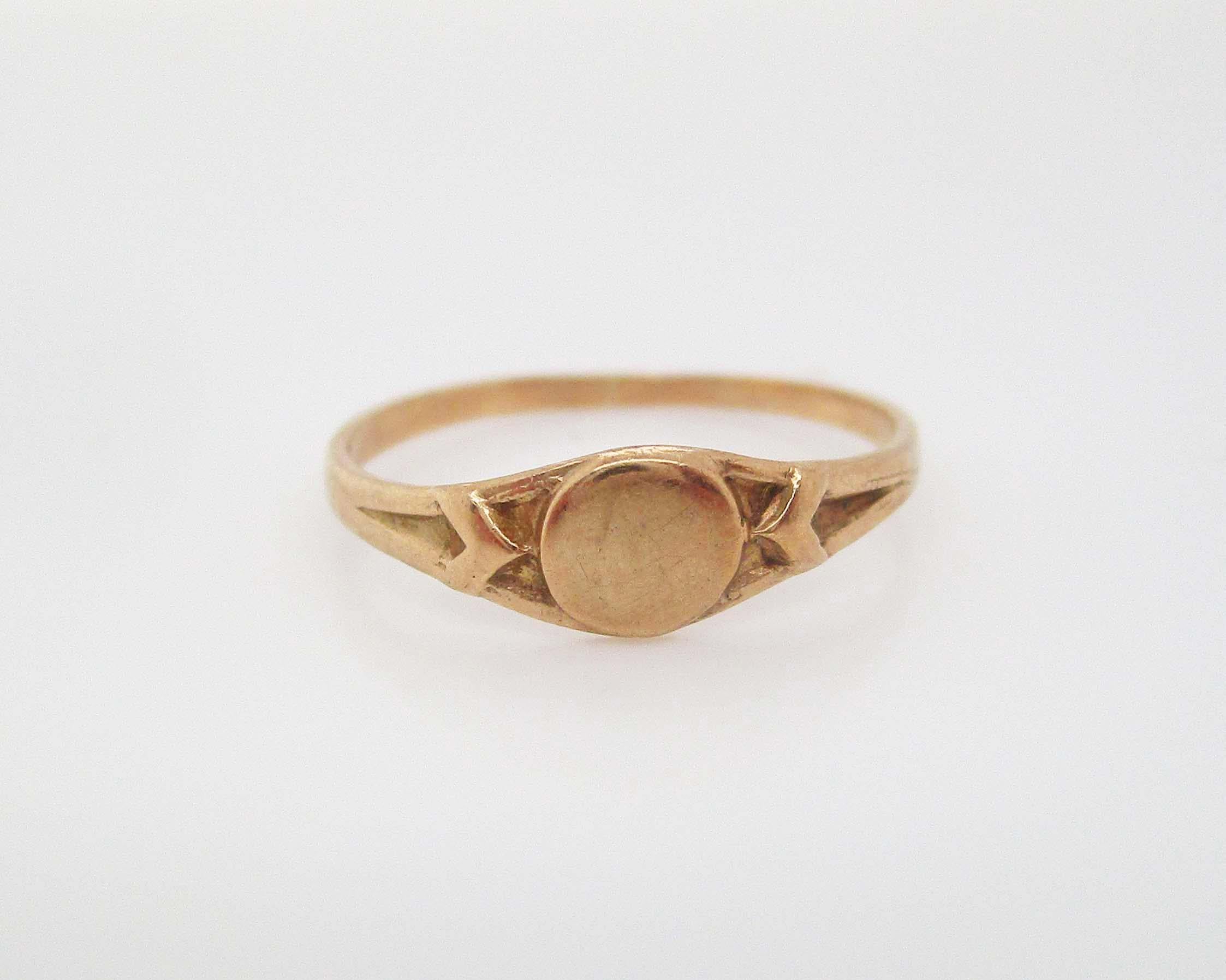 This incredible antique ring is a gorgeous baby ring in 10k yellow gold from the Art Deco period. This ring is the perfect example of a baby ring from this era - the 10k yellow gold is bright and warm, and the simple signet layout of the ring makes