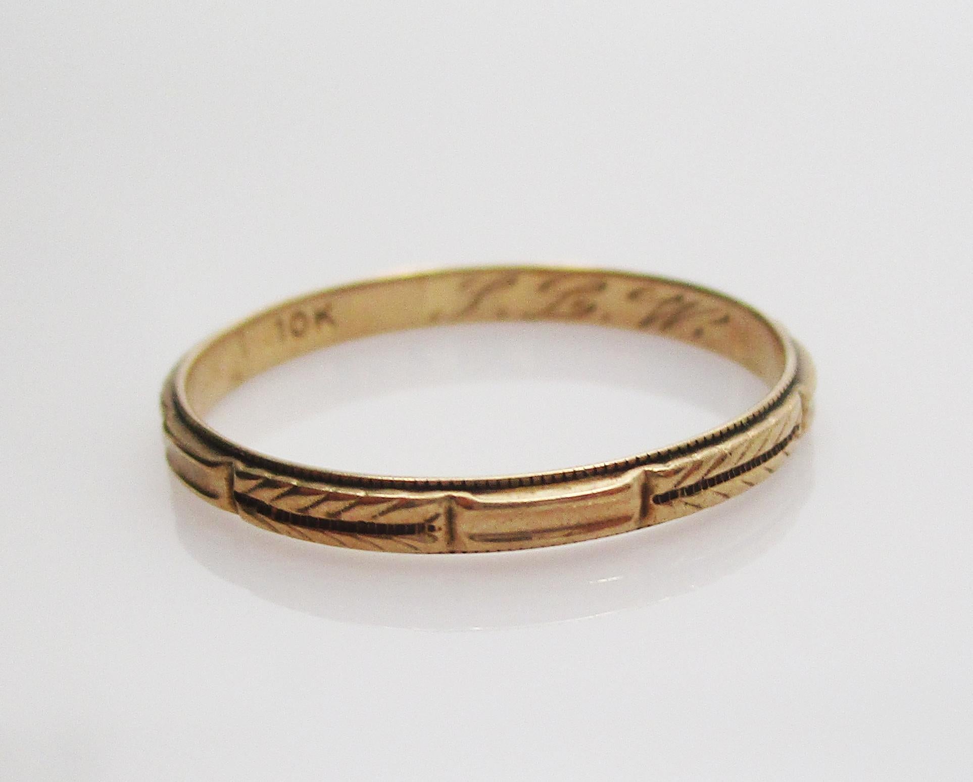 This is a lovely Art Deco wedding band ring in 10 k yellow gold with elegant engraved details! This ring is in great condition with beautiful fine details, including a delicate braid pattern and subtle milgraining on the edges of the band! The