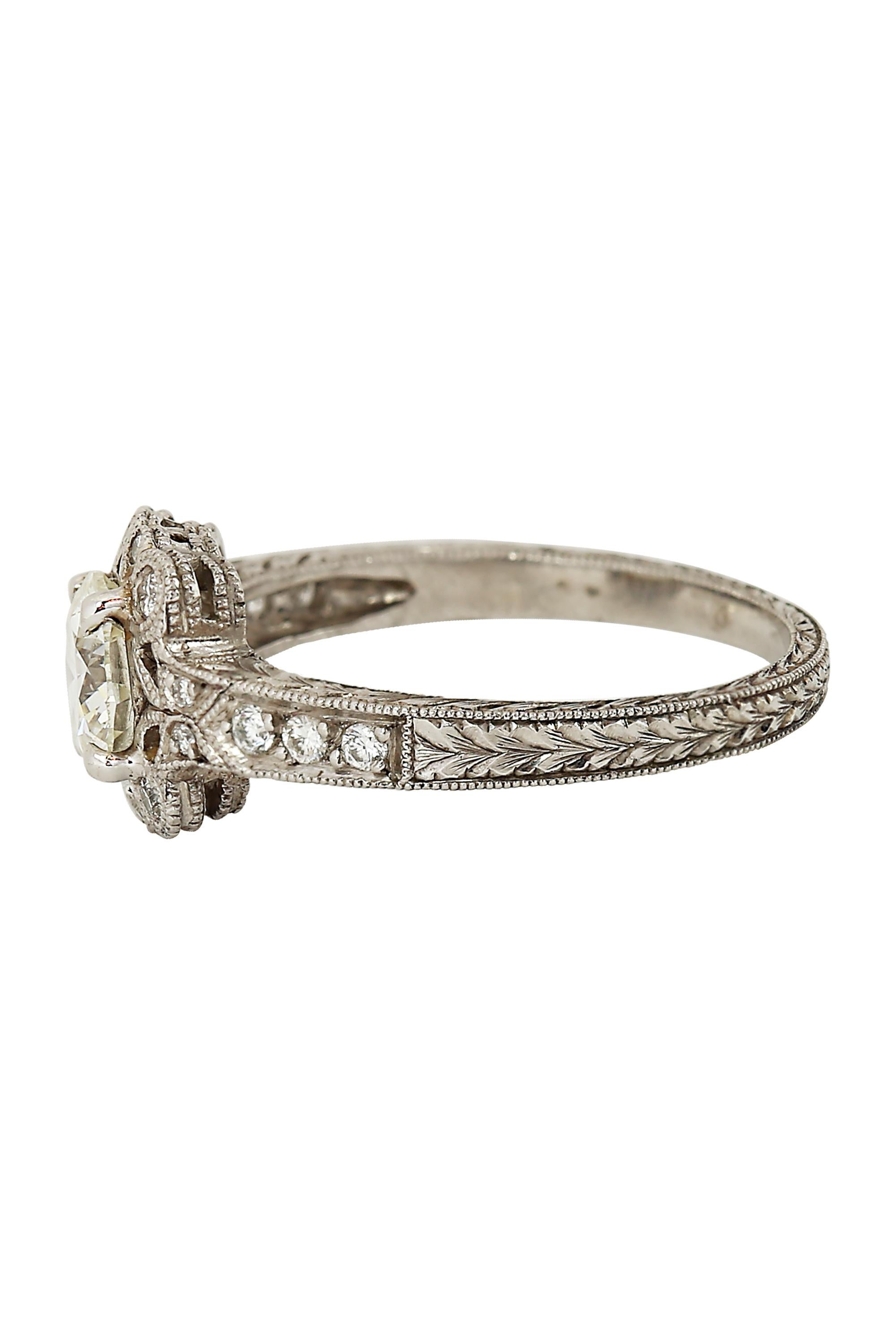 A true Art Deco masterpiece, this exquisite ring features a stunning round brilliant cut diamond weighing approximately 1.20 carats. The center diamond, graded G in color and VVS2 in clarity, sparkles brilliantly in a refined platinum mounting. The