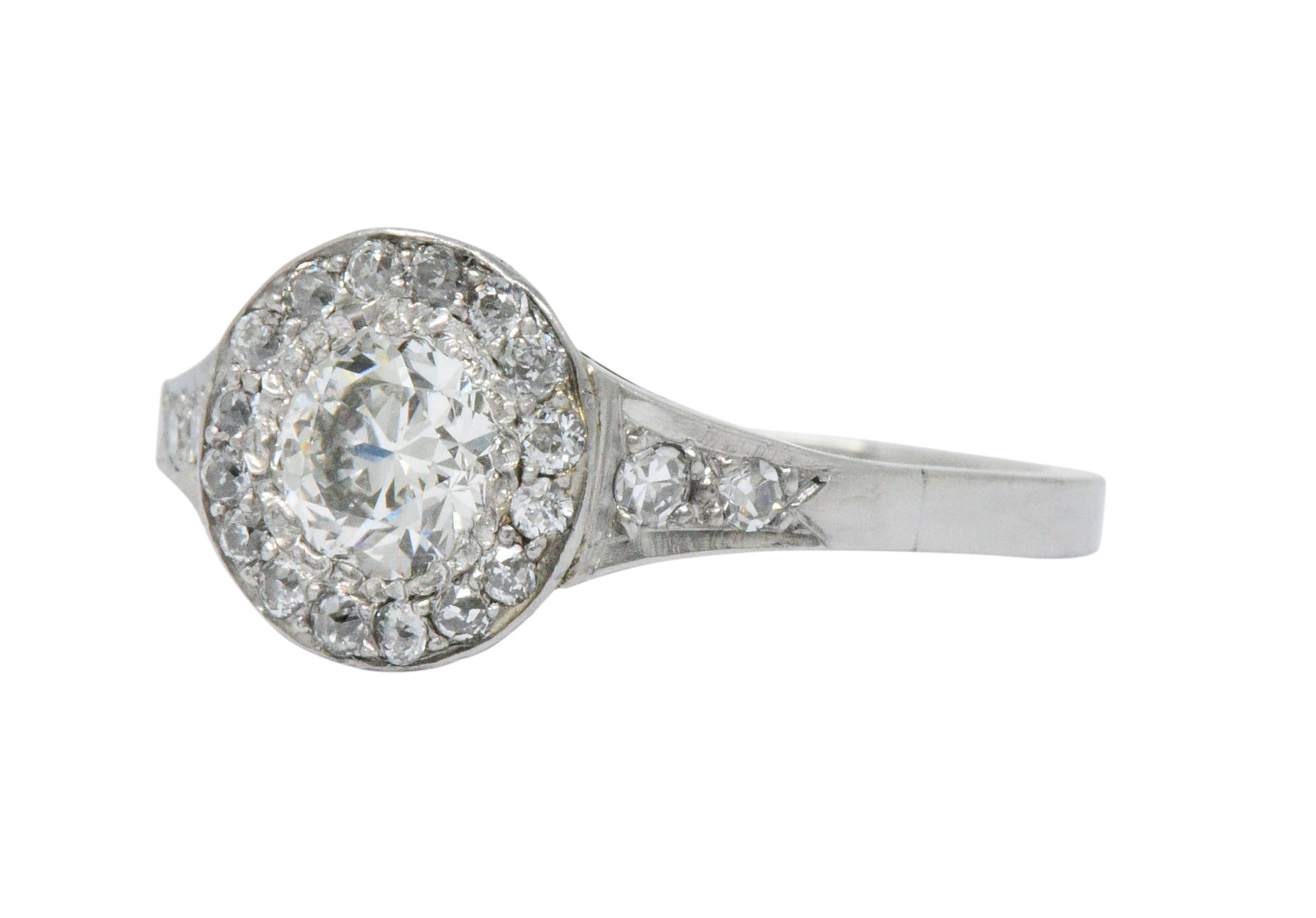 Centering an old European cut diamond weighing approximately 0.75 carat, I color with VS clarity

Surrounded by a circular halo of old European cut diamonds and flanked by shoulders bead set with single cut diamonds

Accent diamond weight weighs
