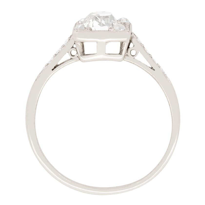 Crafted in platinum, this stunning Art Deco Solitaire ring features a 1.10 carat Old Cushion Cut diamond as its centrepiece. The diamond is graded I in colour and SI1 in clarity. Adorning each corner of the central stone and down the shoulders a