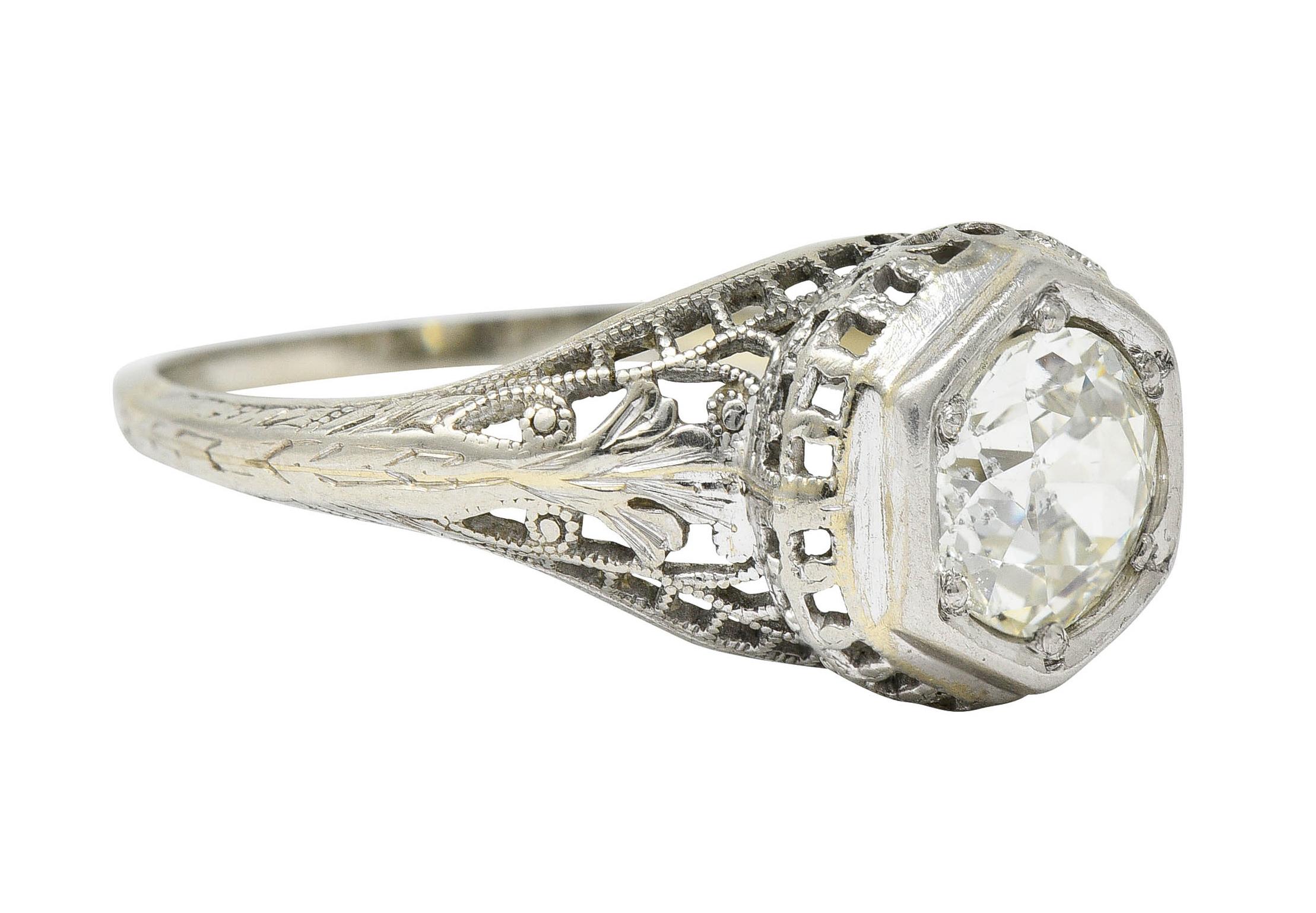 Centering an old European cut diamond weighing 1.12 carats - M color with SI2

Set in a hexagonal head of a pierced and stylized bombè mounting

With a milgrain trellis motif throughout and engraved foliate details

Stamped 18K for 18 karat