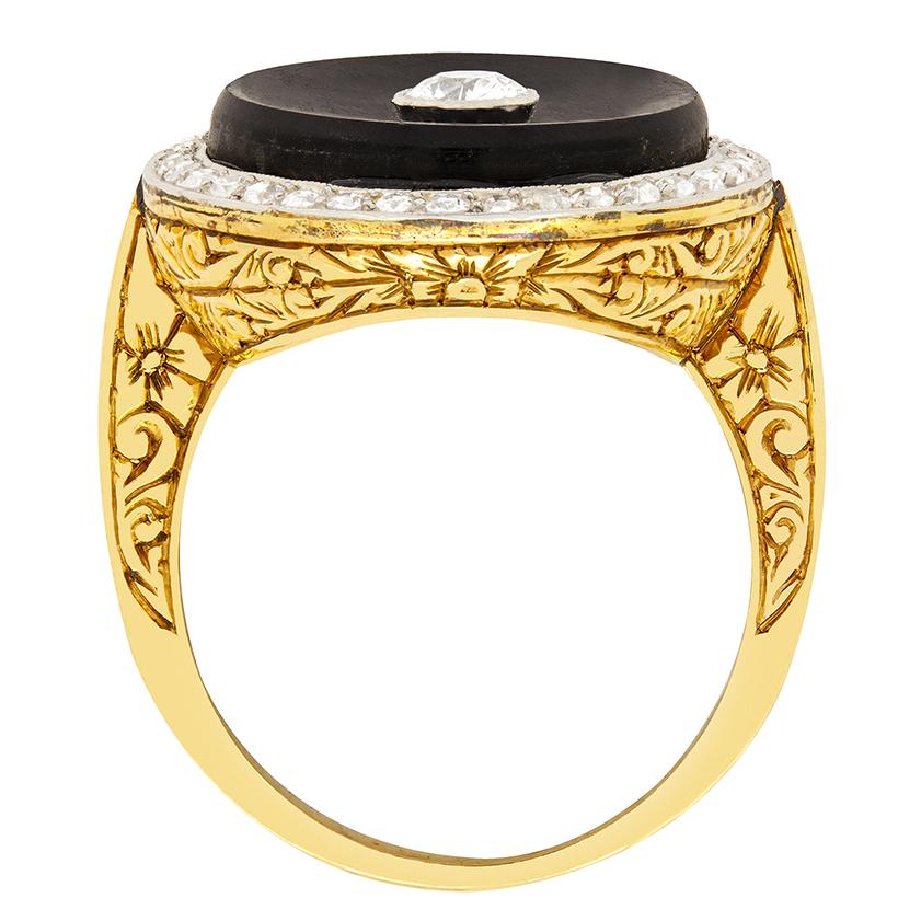 This bold cocktail ring features a large circular onyx with an old cut diamond in its centre. The central diamond is 0.40 carat and has been graded G in colour and VS in clarity. Around the outside of the onyx is a further halo of old cut diamonds