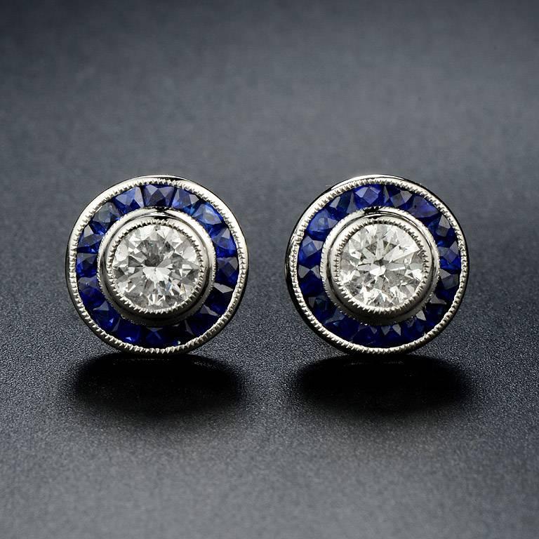 Halo Stud Earrings 1.14 Carat Weight Diamond G Color SI Clarity in the center.  Both are surrounded by French Cut Natural Blue Sapphire 32 pieces 1.15 Carat.

The Earrings are made of Platinum 900.